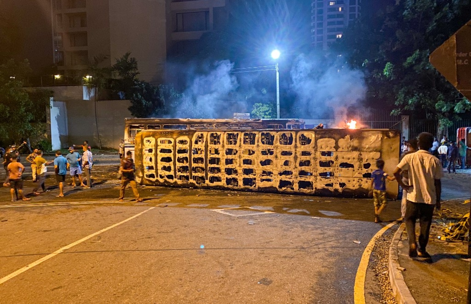 މެއި 10، 2022 - ކޮލަމްބޯ: ސްރީ ލަންކާގައި ހިނގަމުންދާ ހަމަނުޖެހުންތަކުގައި އިސްތިއުފާ ދެއްވި ބޮޑުވަޒީރު މަހިންދަ ރާޖަޕަކްސަގެ ގެކޮޅު ބޭރުގައި އޮތް ވެހިކަލެއްގައި ރޯކޮށްލާފައި. -- ފޮޓޯ: އޭއެފްޕީ