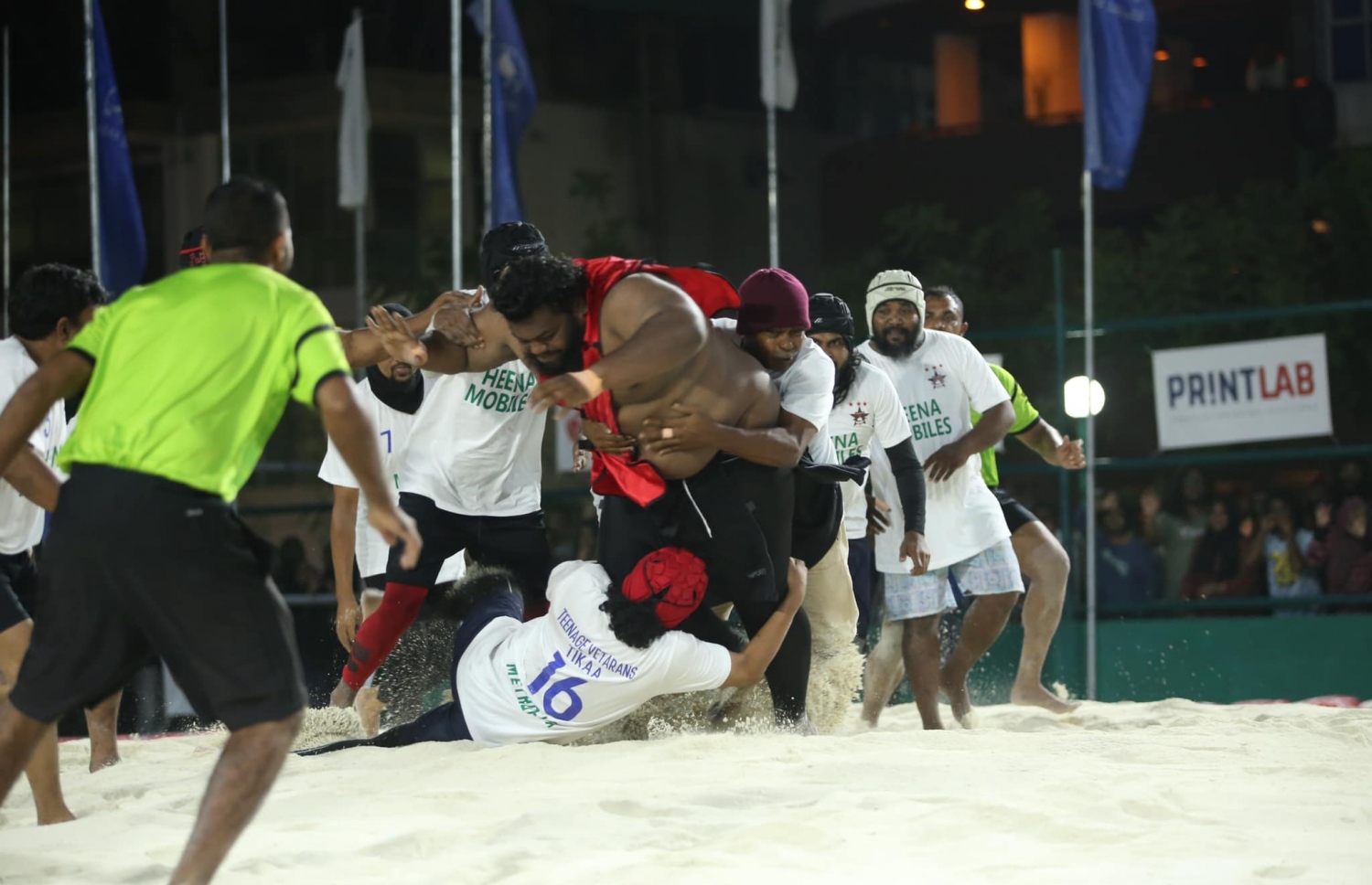 އެލްޓީ ސްޕޯޓްސް ކްލަބާއި ޓީނޭޖް ވެޓެރަންސް ބައްދަލުކުރި މެޗުގެ ތެރެއިން؛ ވެޓެރަންސް އެތެރޭގައި، އެލްޓީގެ ކުޅުންތެރިއަކު ހިފަހައްޓަނީ.-- ފޮޓޯ: ބައިބަލާ އެސޯސިއޭޝަން