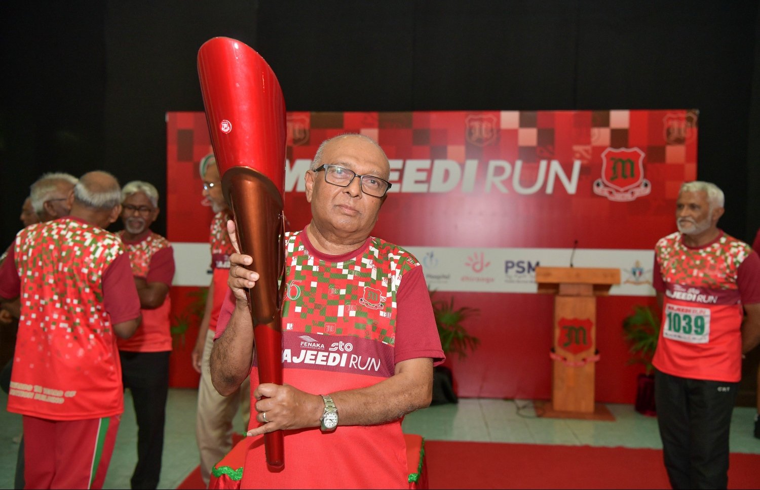 މަޖީދިއްޔާ ސްކޫލްގެ 95 ވަނަ އަހަރީ ދުވަސް ފާހަގަކުރަން 95 ގަޑިއިރުގެ ދުވުން ފެށުމަށް ބޭއްވި ރަސްމިއްޔާތުގައި އެ ސްކޫލުގެ ކުރީގެ އިސްވެރިއެއް ގޮތުގައި މަސައްކަތް ކުރެއްވި ވިލާ ކޮލެޖުގެ ރެކްޓާ ޑރ. އަންވަރު ދަންމަރު ހިފައިގެން ފޮޓޯއަކަށް ހުއްޓިގެން.-- ފޮޓޯ: ނިޝާން އަލީ /މިހާރު