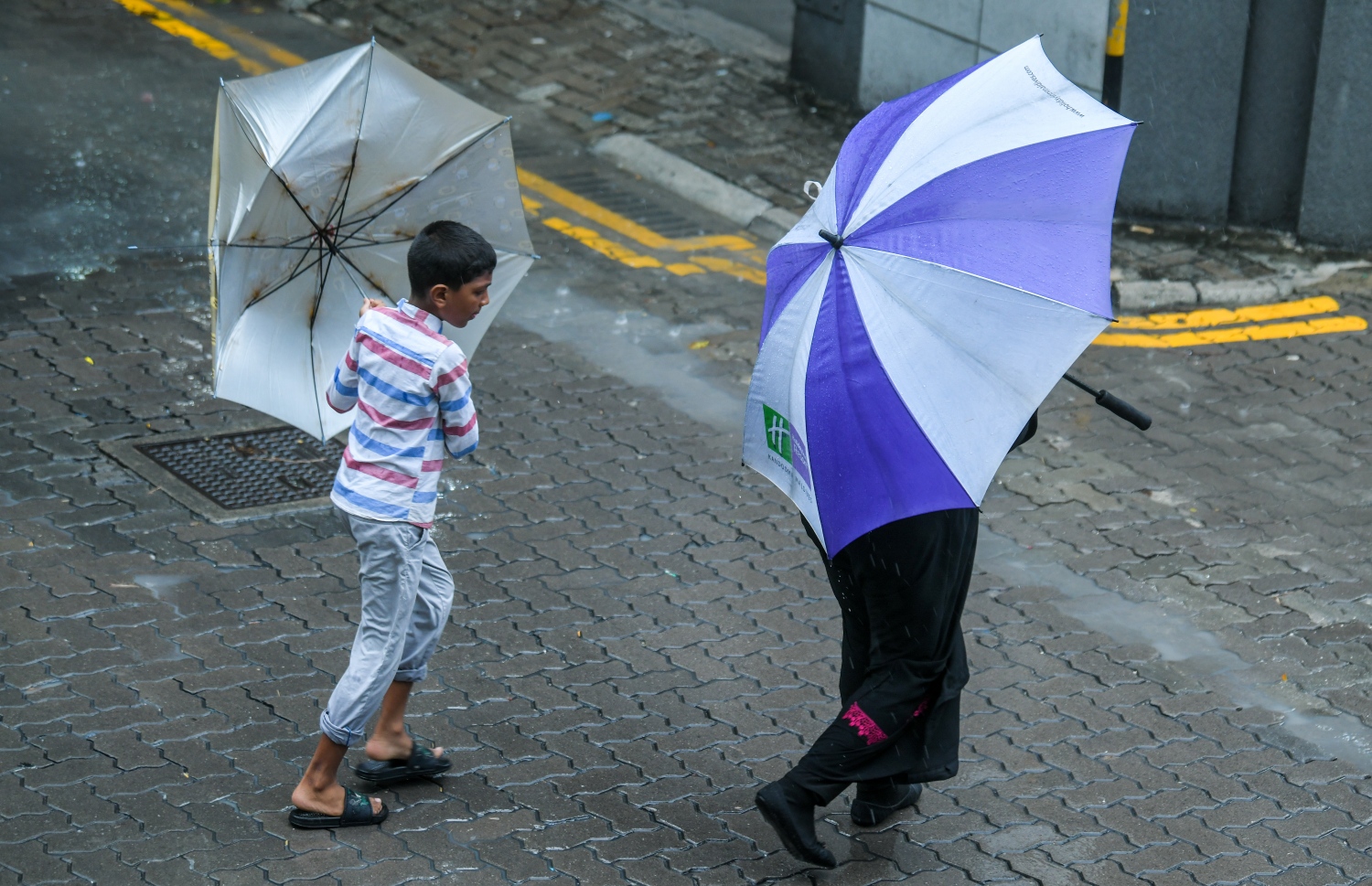 މާލެއަށް ވިއްސާރަ ދުވަހެއްގައި ކުޑަ އަޅައިގެން ތިބި އަންހެނަކާއި ކުޑަކުއްޖަކު މަގު ހުރަސްކުރަނީ.-- ފޮޓޯ: މިހާރު