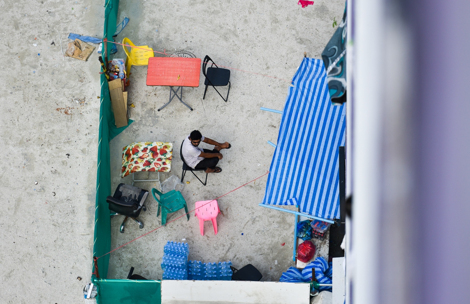 ހިޔާ ޓަވަރުތަކިގެ ތިރީގައި ހިދުމަތްދެމުންދިޔަ ފުޓް ސްޓޯލެއްގައި މީހަކު އިށީންދެލައިގެން: މި ތަންތަން ނެގުމުގެ މަސައްކަތް އެޗްޑީސީން ވަނީ މިއަދު ފަށާފަ -- ފޮޓޯ: ފަޔާޒު މޫސާ | މިހާރު