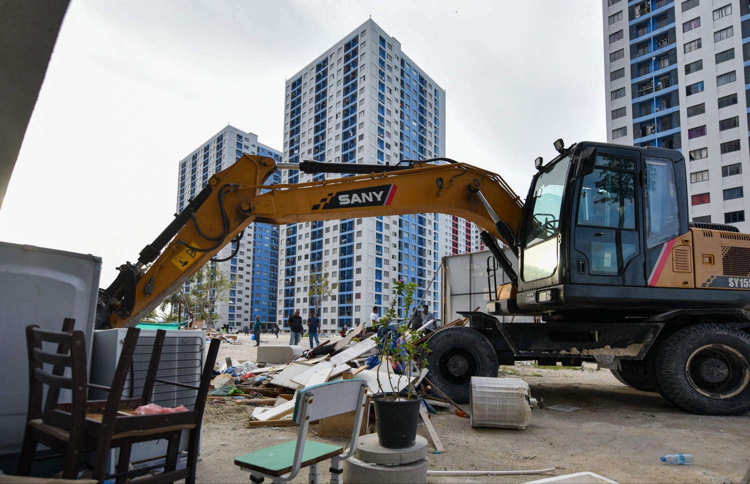 ޓަވަރުތަކުގެ ބޭރުގައި ގަވައިދާ ހިލާފަށް ވިޔަފާރިކުރަމުން ގެންދިއަ ގާޑިޔާތައް އެޗްޑީސީގެ ފަރާތުން އެކްސްކަވޭޑަރަކުން ނަގަނީ -- ފޮޓޯ: ފަޔާޒު މޫސާ | މިހާރު