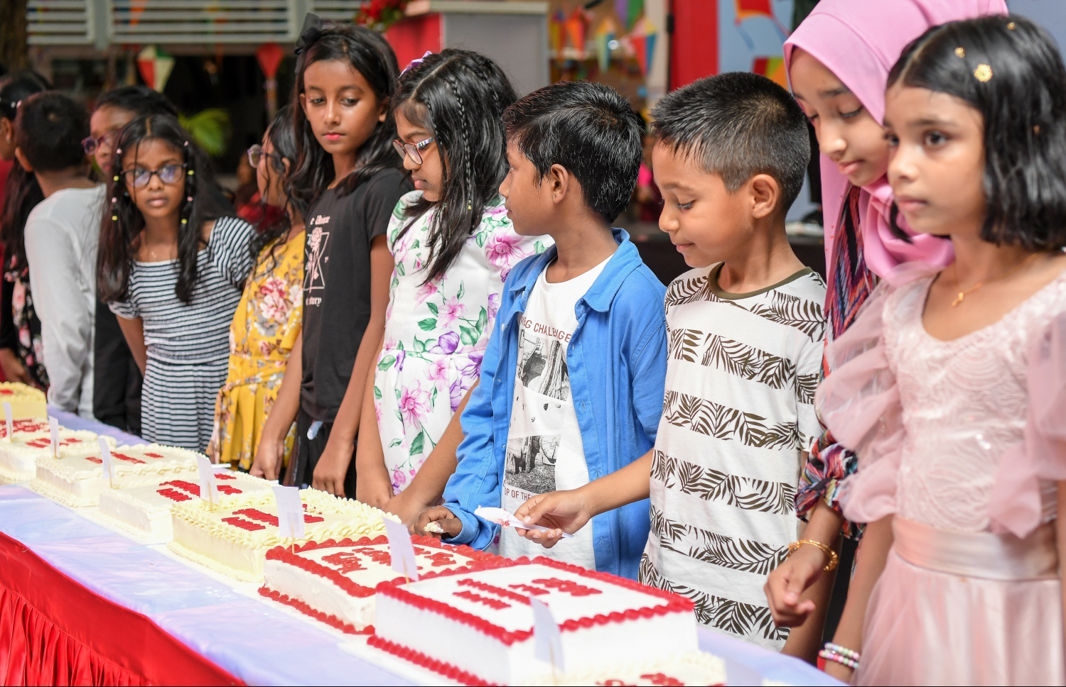 މާލެ- މޭ 23، 2022: އިސްކަންދަރު ސްކޫލުގެ 61 ވަނަ އަހަރީ ދުވާހާއި އެއްކޮށް ކުޑަކުދިންގެ ދުވަސް ފާހަގަކުރުމަށް އެ ސްކޫލުގެ ޕްލޭ ގްރައުންޑްގައި ބޭއްވި ހާއްސަ އެސެމްބްލީގައި އެ ސްކޫލްގެ ދަރިވަރުން ކޭކު ފަޅަނީ--. ފޮޓޯ: ނިޝާން އަލީ /މިހާރު