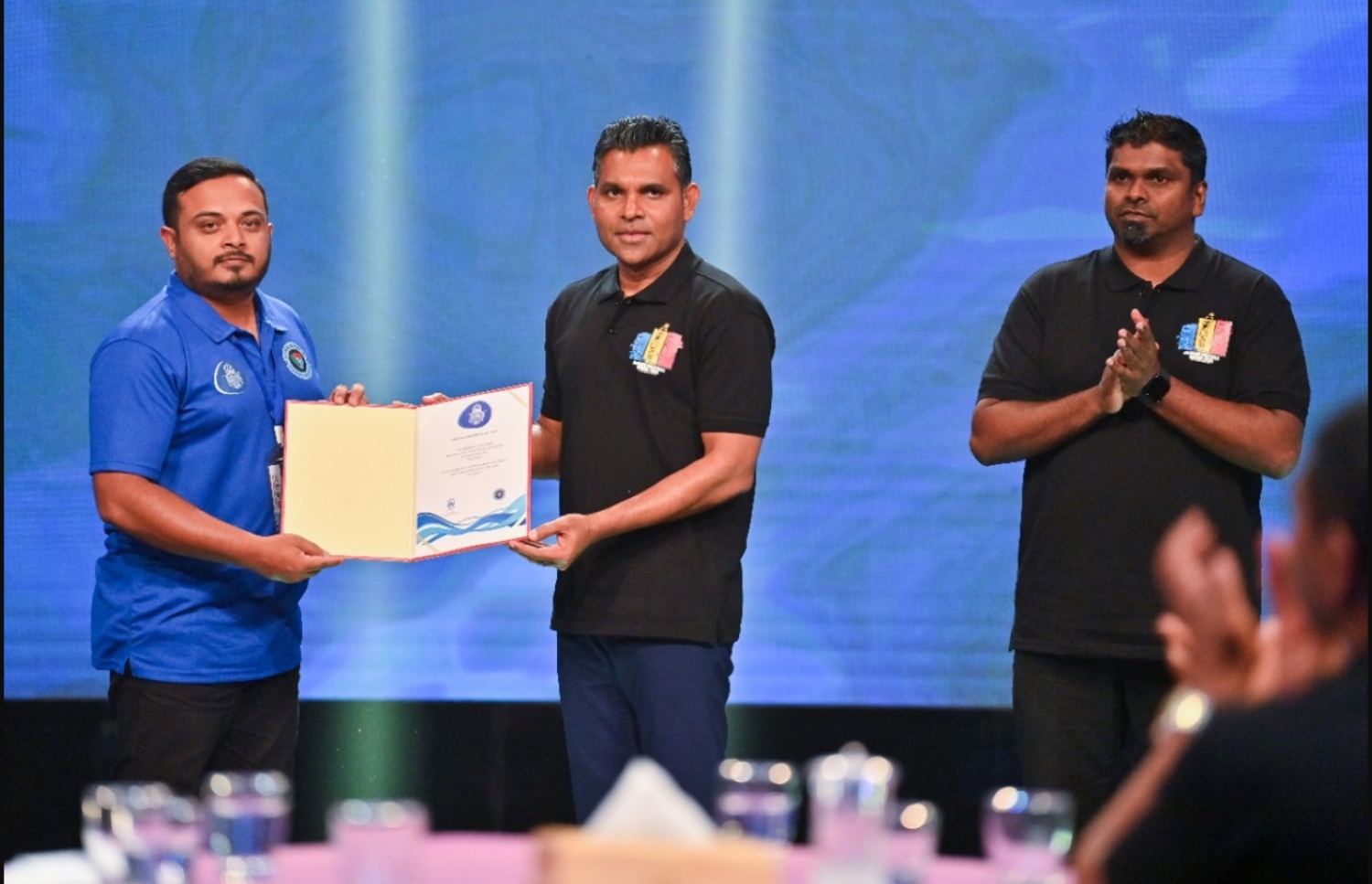 ވީއޭއެމުން ގެނައި ބިދޭސީ ކުޅުންތެރިން ޓީމުތަކަށް ހަމަޖެއްސުމަށް ފަހު އެކަމުގެ ލިޔުން، ނައިބު ރައީސް ފައިސަލް ނަސީމް ހަވާލުކޮށްދެއްވާއިރު އަރިހުގައި ރަނޭ. --- ފޮޓޯ: ވީއޭއެމް