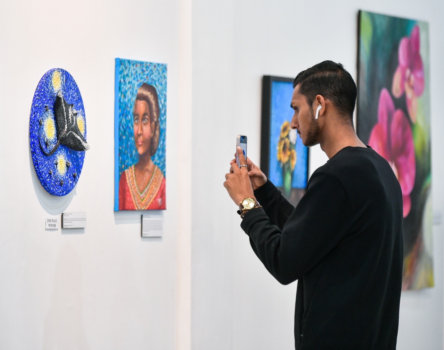 ނެޝަނަލް އާޓް ގެލެރީގައި ކުރިއަށްދާ އެގްޒިބިޝަންގައި ހުރި އާޓް ވޯކްތަކެއްގެ ފޮޓޯ ނަގަނީ --- ދޯ ފޮޓޯ : ފަޔާޒް މޫސާ