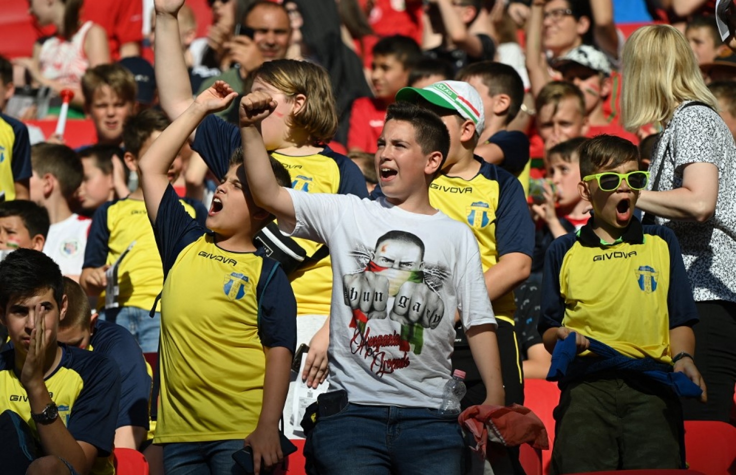 ކުޅިބަލަން ދަނޑަށް ވަދެ ތިބި ހަންގޭރީގެ ބައެއް ސަޕޯޓަރުން: ޔޫއެފާގެ ގަވާއިދާ އެއްގޮތަށް ހަންގޭރީން ދަނޑަށް ވައްދާފައި ވަނީ 14 އަހަރުން ދަށުގެ ކުޑަކުދިން، ބެލެނިވެރިއަކާ އެކު.-- ފޮޓޯ: އޭއެފްޕީ