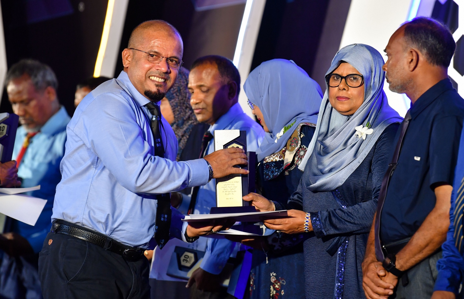 ސްޓެލްކޯ އަށް ދިގު މުއްދަތެއް ވަންދެން ހިދުމަތްކުރި މުވައްޒަފަކަށް، އެ ކުންފުނީގެ އެމްޑީ ޝަރީފް ރޭ އިނާމު ދެއްވަނީ.---ފޮޓޯ: ރައީސް އޮފީސް