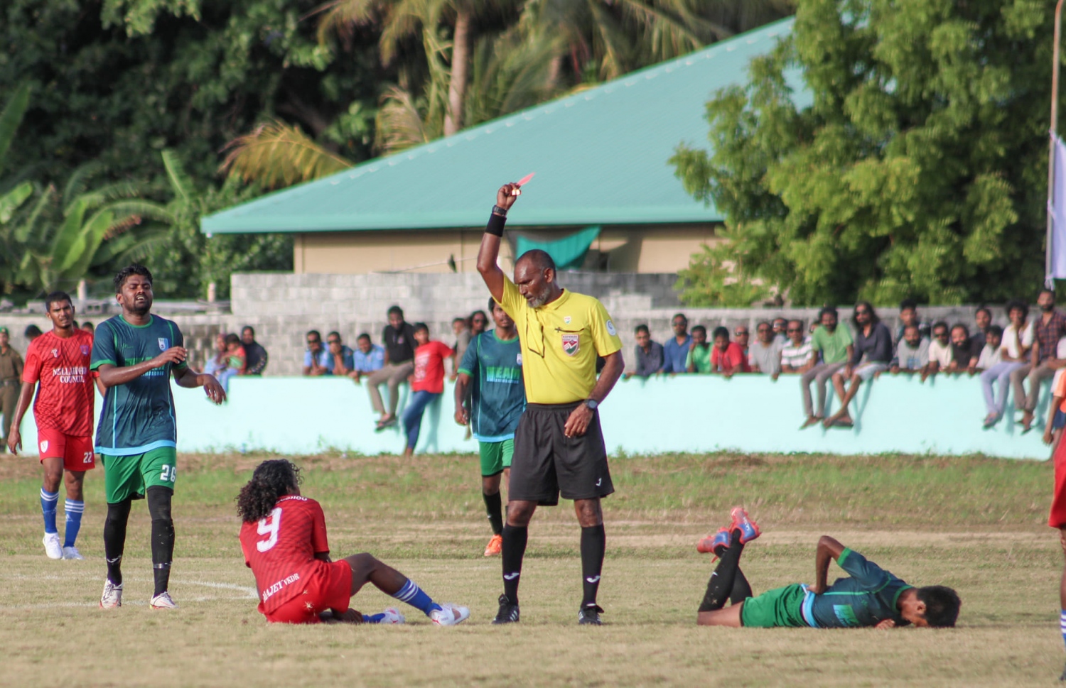 ޓީމް ނެއްލައިދޫގެ އަސްލަމް (9) އަށް ރެފްރީ މުހައްމަދު ހަމްދީ ރަތް ކާޑު ދައްކަނީ.-- ފޮޓޯ: ޓީމް ހަނިމާދޫ މީޑީއާ