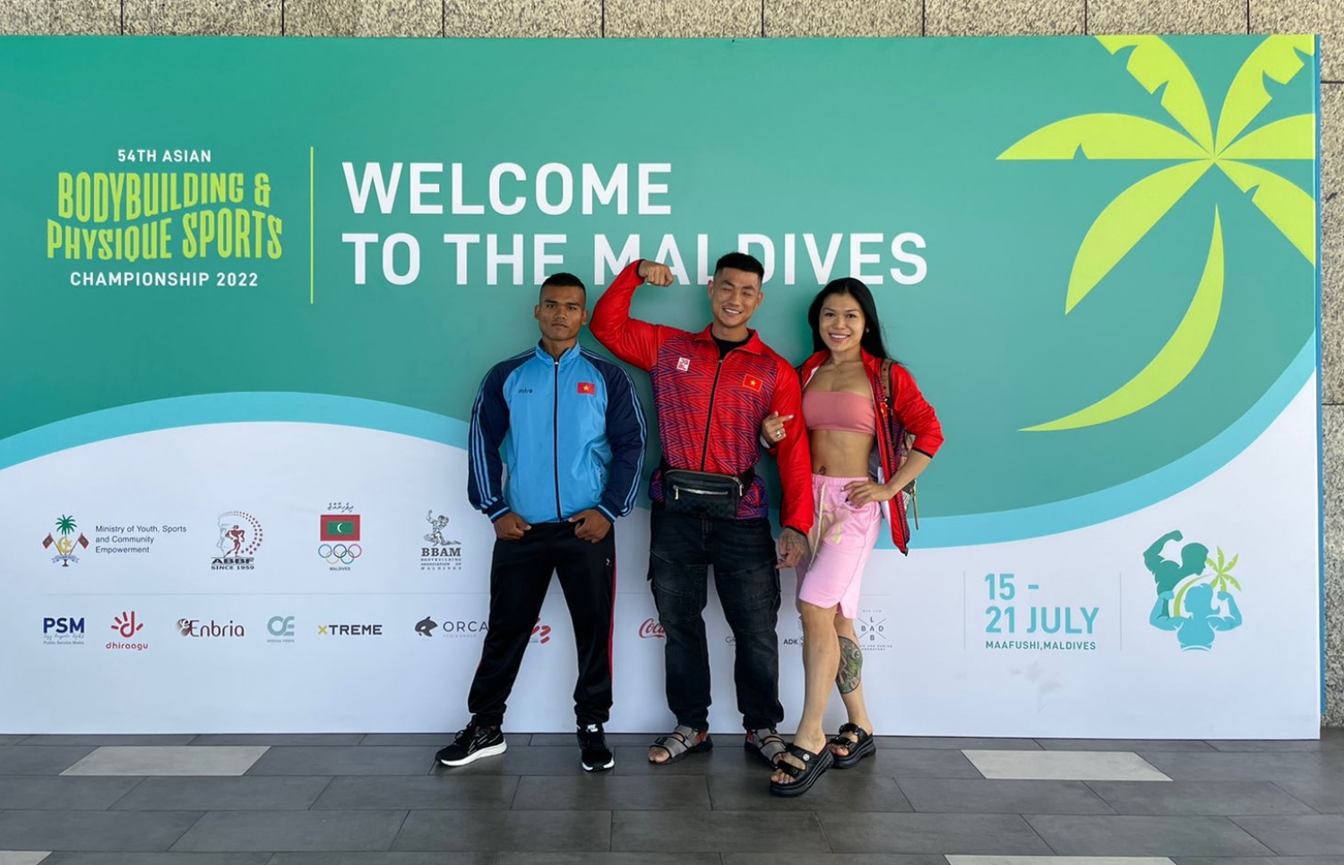 ރާއްޖޭގައި ބާއްވާ 54 ވަނަ އޭޝިއަން ބޮޑީބިލްޑިންގް ޗެމްޕިއަންޝިޕްގައި ވާދަކުރަން އައި ވިއެޓްނާމް ޓީމުގެ ބައެއް އެތުލީޓުން، މުބާރާތް ޕްރޮމޯޓް ކުރަން ވެލާނާ އިންޓަނޭޝަނަލް އެއާޕޯޓުގައި ހަރުކޮށްފައިވާ ބިލްބޯޑް ކައިރީގައި ފޮޓޯއަކަށް ހުއްޓިގެން: މި މުބާރާތް އޮންނާނީ ކ. މާފުށްޓާއި ކްރޮސް ރޯޑްސް މޯލްޑިވްސްގައި ޖުލައި 15-21 އަށް.--- ފޮޓޯ: ބީބީއޭއެމް