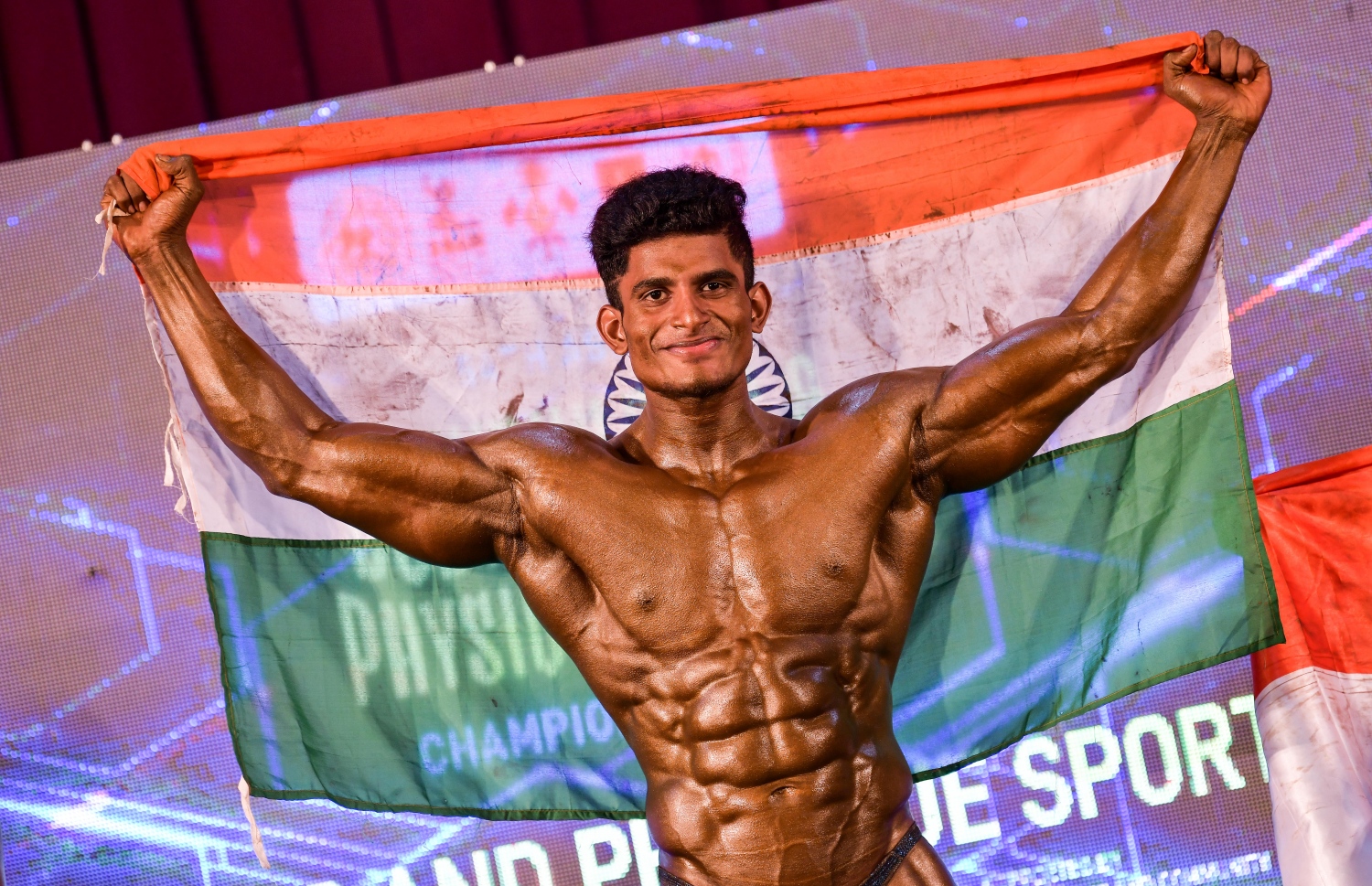 ރާއްޖޭގައި މިއަދު ފެށި އޭޝިއާގެ ބޮޑީ ބިލްޑިން ޗެމްޕިއަންޝިޕްގައި މިއަދު ކުރިއަށް ގެންދިޔަ އިވެންޓަކުން ވަނަ ހޯދި އިންޑިއާގެ އެތްލީޓަކު އެ ގައުމުގެ ދިދަ ހިފައިގެން.--- ފޮޓޯ: ނިޝާން އަލީ/މިހާރު