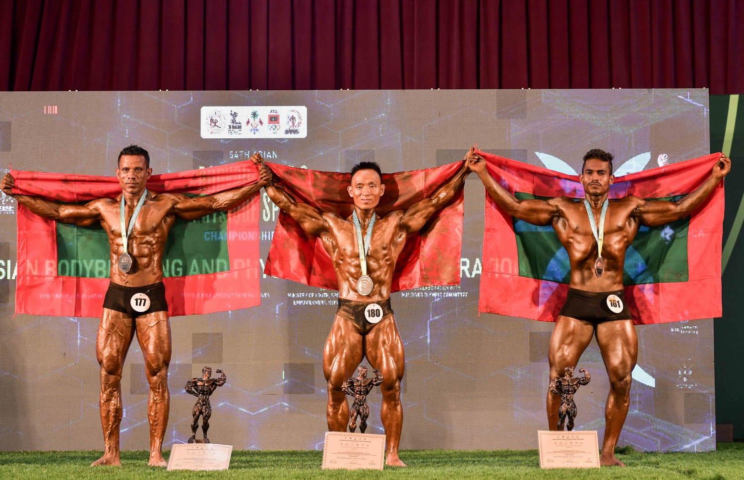 އޭޝިއަން ބޮޑީ ބިލްޑިން ޗެމްޕިއަންޝިޕްގައި އެތުލެޓިކް ފިޒިކް 160 ސީއެމް ކެޓަގަރީގެ ރިހި މެޑަލް ހޯދި ދިވެހި އެތުލީޓް ފަތުހުﷲ މުހައްމަދު (ވ) އަދި ބްރޯންޒް މެޑަލް ހޯދި މުހައްމަދު ޒިދާން (ކ) މެޑަލް ހޯދުމަށް ފަހު، ދިވެހި ދިދައާއެކު.--- ފޮޓޯ: ނިޝާން އަލީ/މިހާރު