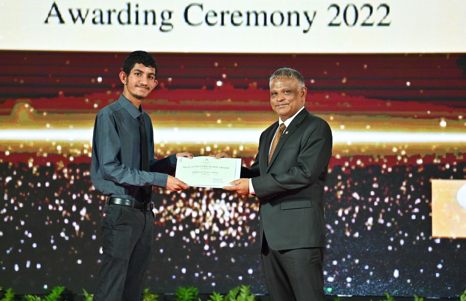 ރައީސް ދެއްވާ ހާއްސަ ސްކޮލަޝިޕާއި ހައި އެޗީވާސް ސްކޮލަޝިޕްގެ ލިޔުން ހަވާލު ކުރުމަށް ގިޔާސުއްދީން ސްކޫލުގައި ބޭއްވި ހަފުލާގައި ހަޔާ އެޑިއުކޭޝަން ޑރ. މިނިސްޓަރު އިބްރާހިމް ހަސަން، ހައި އެޗީވާސް ސްކޮލަޝިޕް ލިބުނު ދަރިވަރަކަށް ލިޔުން ހަވާލު ކުރައްވަނީ.-- ފޮޓޯ: ރައީސް އޮފީސް