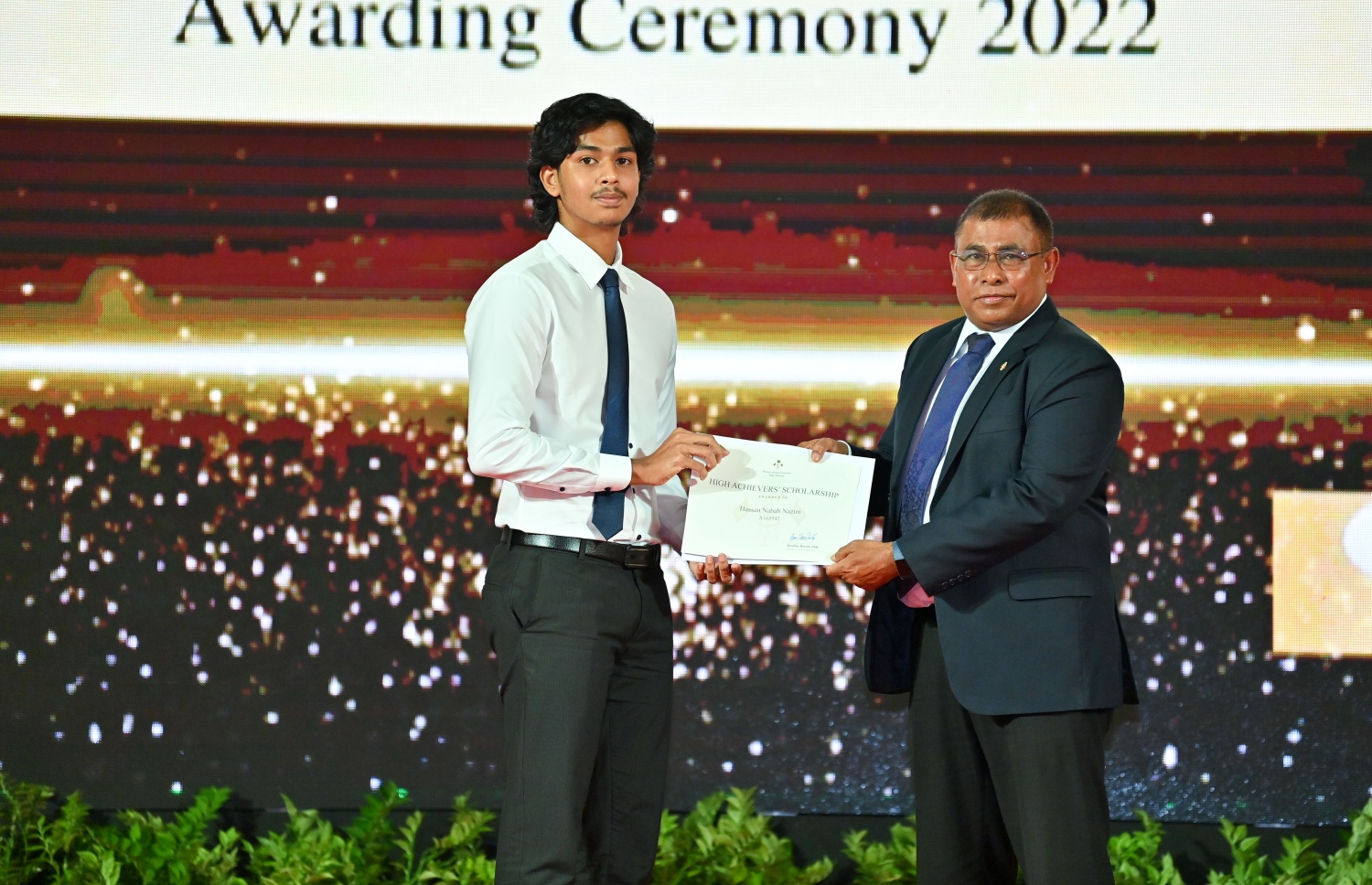 ރައީސް ދެއްވާ ހާއްސަ ސްކޮލަޝިޕާއި ހައި އެޗީވާސް ސްކޮލަޝިޕްގެ ލިޔުން ހަވާލު ކުރުމަށް ގިޔާސުއްދީން ސްކޫލުގައި ބޭއްވި ހަފުލާގައި ޓޫރިޒަމް މިނިސްޓަރު އަބްދުﷲ މައުސޫމް، ހައި އެޗީވާސް ސްކޮލަޝިޕް ލިބުނު ދަރިވަރަކަށް ލިޔުން ހަވާލު ކުރައްވަނީ.-- ފޮޓޯ: ރައީސް އޮފީސް