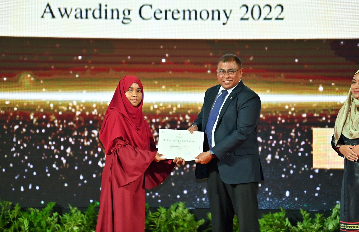 ރައީސް ދެއްވާ ހާއްސަ ސްކޮލަޝިޕާއި ހައި އެޗީވާސް ސްކޮލަޝިޕްގެ ލިޔުން ހަވާލު ކުރުމަށް ގިޔާސުއްދީން ސްކޫލުގައި ބޭއްވި ހަފުލާގައި ޓޫރިޒަމް މިނިސްޓަރު އަބްދުﷲ މައުސޫމް، ހައި އެޗީވާސް ސްކޮލަޝިޕް ލިބުނު ދަރިވަރަކަށް ލިޔުން ހަވާލު ކުރައްވަނީ.-- ފޮޓޯ: ރައީސް އޮފީސް