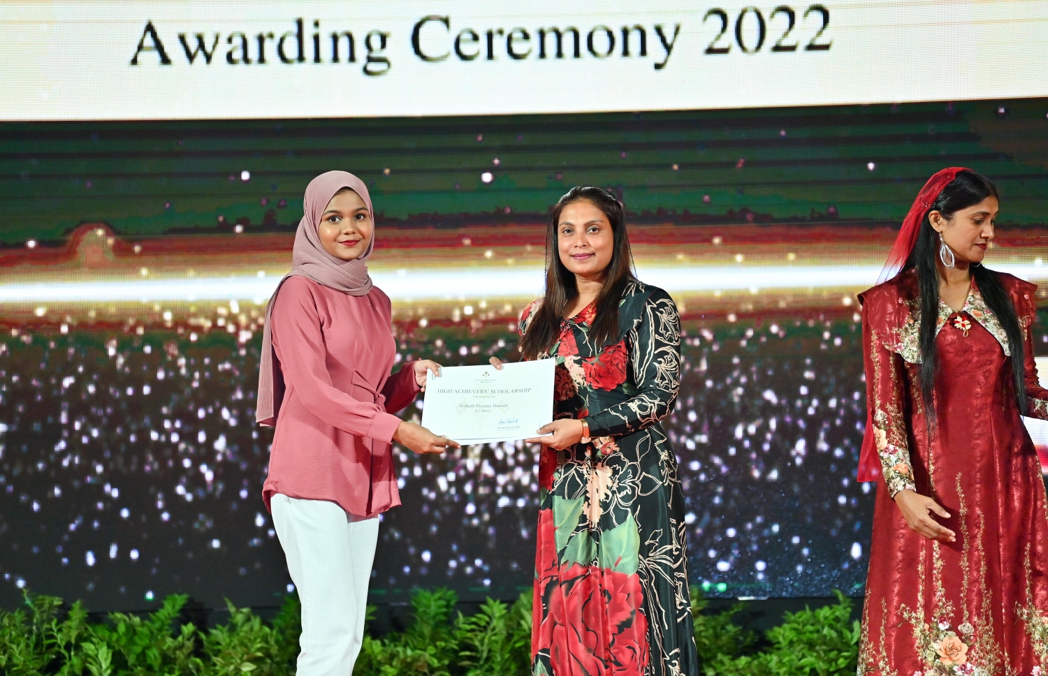 ރައީސް ދެއްވާ ހާއްސަ ސްކޮލަޝިޕާއި ހައި އެޗީވާސް ސްކޮލަޝިޕްގެ ލިޔުން ހަވާލު ކުރުމަށް ގިޔާސުއްދީން ސްކޫލުގައި ބޭއްވި ހަފުލާގައި އެޑިއުކޭޝަން މިނިސްޓަރު އައިޝަތު އަލީ، ހައި އެޗީވާސް ސްކޮލަޝިޕް ލިބުނު ދަރިވަރަކަށް ލިޔުން ހަވާލު ކުރައްވަނީ.-- ފޮޓޯ: ރައީސް އޮފީސް