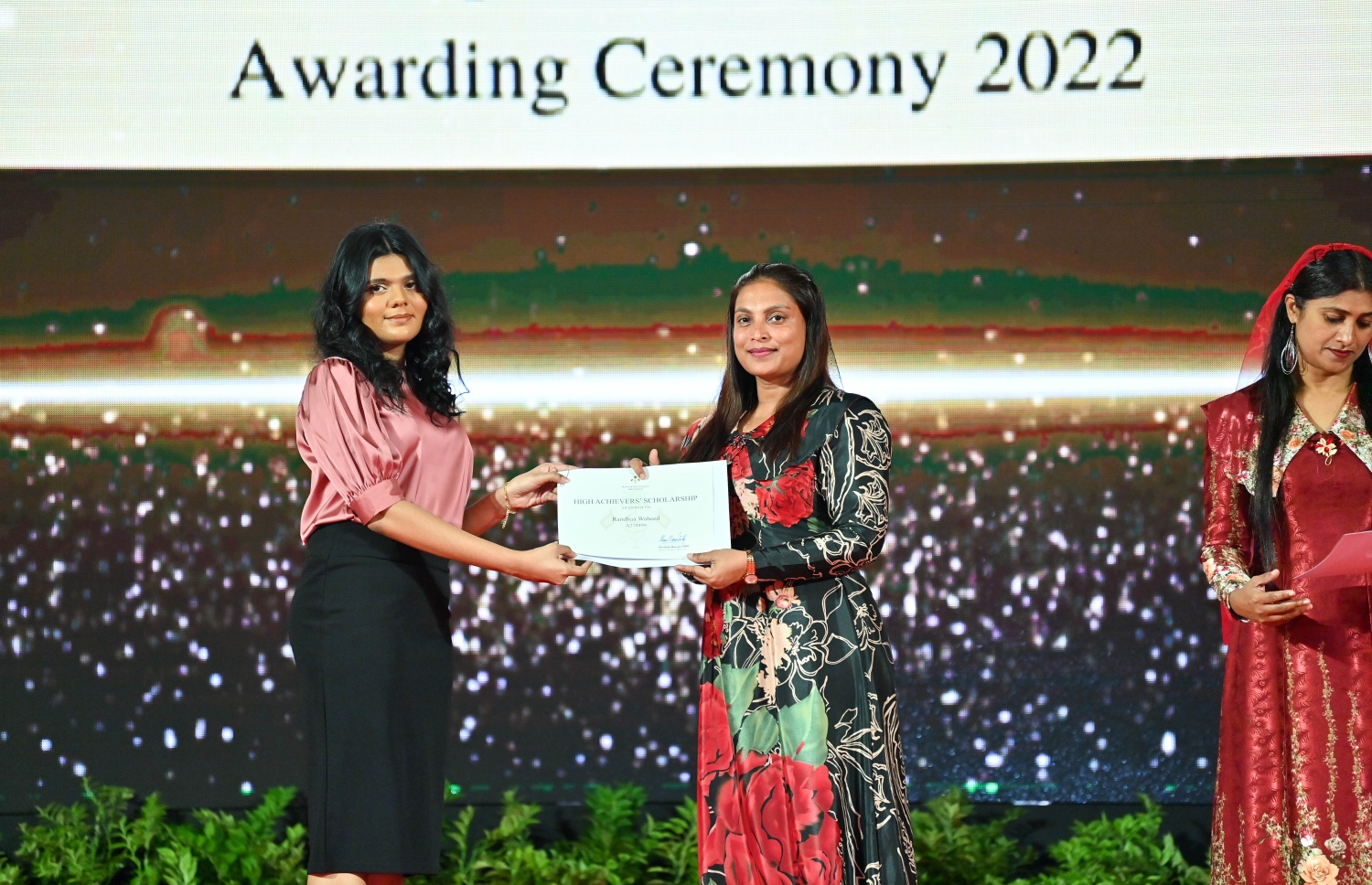 ރައީސް ދެއްވާ ހާއްސަ ސްކޮލަޝިޕާއި ހައި އެޗީވާސް ސްކޮލަޝިޕްގެ ލިޔުން ހަވާލު ކުރުމަށް ގިޔާސުއްދީން ސްކޫލުގައި ބޭއްވި ހަފުލާގައި އެޑިއުކޭޝަން މިނިސްޓަރު އައިޝަތު އަލީ، ހައި އެޗީވާސް ސްކޮލަޝިޕް ލިބުނު ދަރިވަރަކަށް ލިޔުން ހަވާލު ކުރައްވަނީ.-- ފޮޓޯ: ރައީސް އޮފީސް