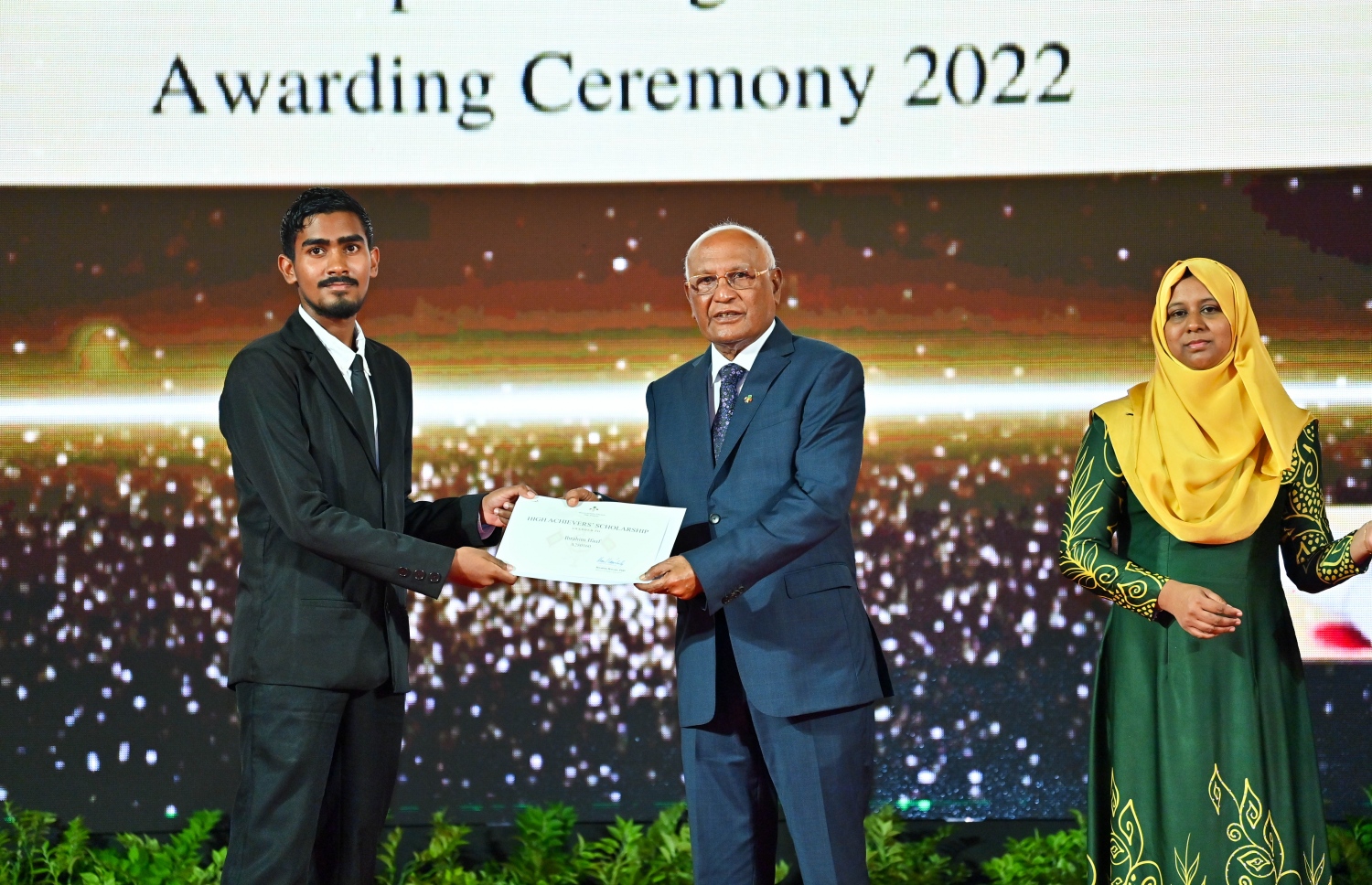 ރައީސް ދެއްވާ ހާއްސަ ސްކޮލަޝިޕާއި ހައި އެޗީވާސް ސްކޮލަޝިޕްގެ ލިޔުން ހަވާލު ކުރުމަށް ގިޔާސުއްދީން ސްކޫލުގައި ބޭއްވި ހަފުލާގައި ހެލްތު މިނިސްޓަރު އަހުމަދު ނަސީމް، ހައި އެޗީވާސް ސްކޮލަޝިޕް ލިބުނު ދަރިވަރަކަށް ލިޔުން ހަވާލު ކުރައްވަނީ.-- ފޮޓޯ: ރައީސް އޮފީސް