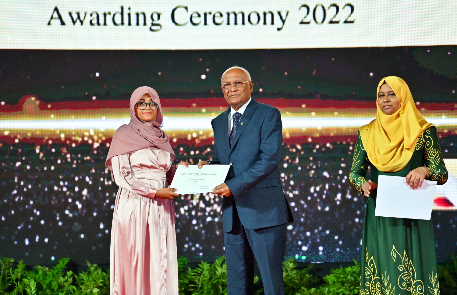 ރައީސް ދެއްވާ ހާއްސަ ސްކޮލަޝިޕާއި ހައި އެޗީވާސް ސްކޮލަޝިޕްގެ ލިޔުން ހަވާލު ކުރުމަށް ގިޔާސުއްދީން ސްކޫލުގައި ބޭއްވި ހަފުލާގައި ހެލްތު މިނިސްޓަރު އަހުމަދު ނަސީމް، ހައި އެޗީވާސް ސްކޮލަޝިޕް ލިބުނު ދަރިވަރަކަށް ލިޔުން ހަވާލު ކުރައްވަނީ.-- ފޮޓޯ: ރައީސް އޮފީސް