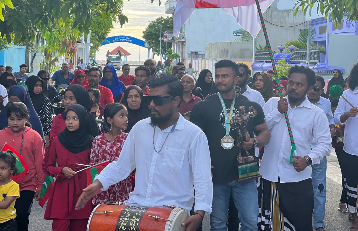 އަޒްނީނަށް މަރުހަބާ ކިޔުމަށް އޭނާގެ އަމިއްލަ ރަށް، ގއ. ވިލިނގިލީގައި ބޭއްވުނު ހަރކާތުގެ ތެރެއިން: އެ ރަށުގެ ގިނަ ބަޔަކު ވަނީ އޭނާ އަށް މަރުހަބާ ކިއޔުމަށް ބަނދަރު ސަރަހައްދަށް ނުކުމެފަ