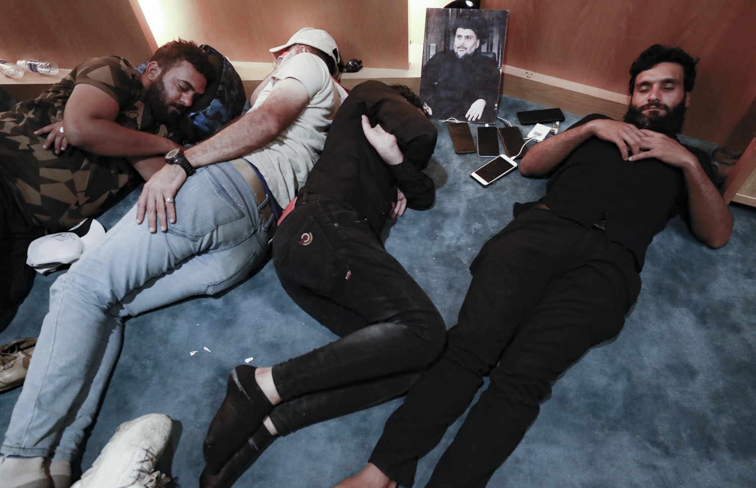 ޖުލައި 30، 2022؛ އިރާގުގެ ވެރިރަށް ބަޣުދާދުގެ ގްރީން ޒޯންގެ ތެރޭގައި ހުންނަ އެ ގައުމުގެ ގާނޫނު ހަދާ މަޖިލީހުގެ އިމާރާތުގެ ތެރޭގައި، މުގްތަދާ އައް ސަދްރުގެ ސަޕޯޓަރުން ނިދަނީ. --އޭއެފްޕީ