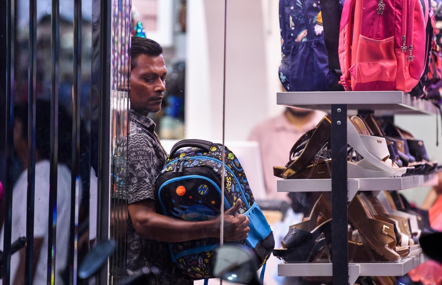 ފިހާރައެއްގައި ހުރި ސްކޫލް ދަބަސްތަކެއް މީހަކު ބަލަނީ -- ފޮޓޯ: ފަޔާޒު މޫސާ | މިހާރު