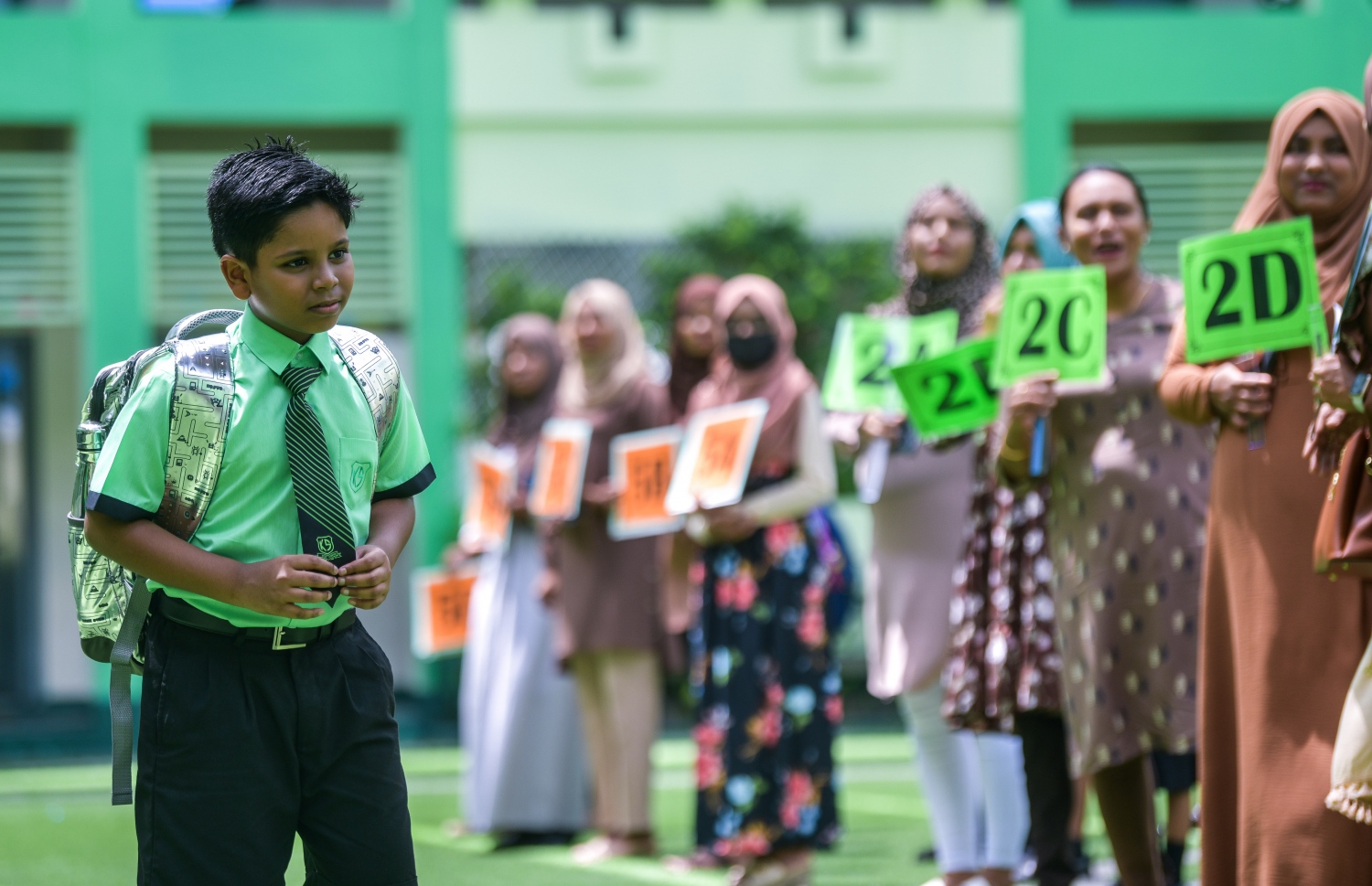 ދިރާސީ އާ އަހަރުގެ ކިޔެވުން ފެށި ފުރަތަމަ ދުވަހު ކަލާފާނު ސްކޫލުގެ ކުއްޖަކު ސްކޫލަށް ވަންނަ އިރު، އެ ސްކޫލުގެ ޓީޗަރުން ކްލާސް ތަކުގެ ބޯޑުތައް ހިފައިގެން ހޯލުގައި އެ ކުދިންނަށް މަރުހަބާ ކިޔަން މަޑުކޮށްލައިގެން.--- ފޮޓޯ: ފަޔާޒު މޫސާ | މިހާރު