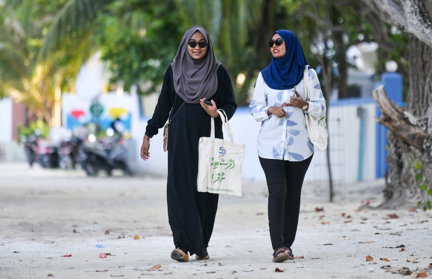 ފުށިފަރު ރިސޯޓުން އިސްނަގައިގެން ޅ އަތޮޅުގައި ކުރިއަށް ގެންދާ "ޕްލާސްޓިކާ ނުލާ" ކެމްޕެއިންގައި ދޭ ފޮތި ކޮތަޅު ހިފައިގެން ޅ. ހިންނަވަރުގެ ދެ އަންހެންކުދިން ހިނގާފައި އަންނަނީ. .-- ފޮޓޯ: ފަޔާޒު މޫސާ | މިހާރު