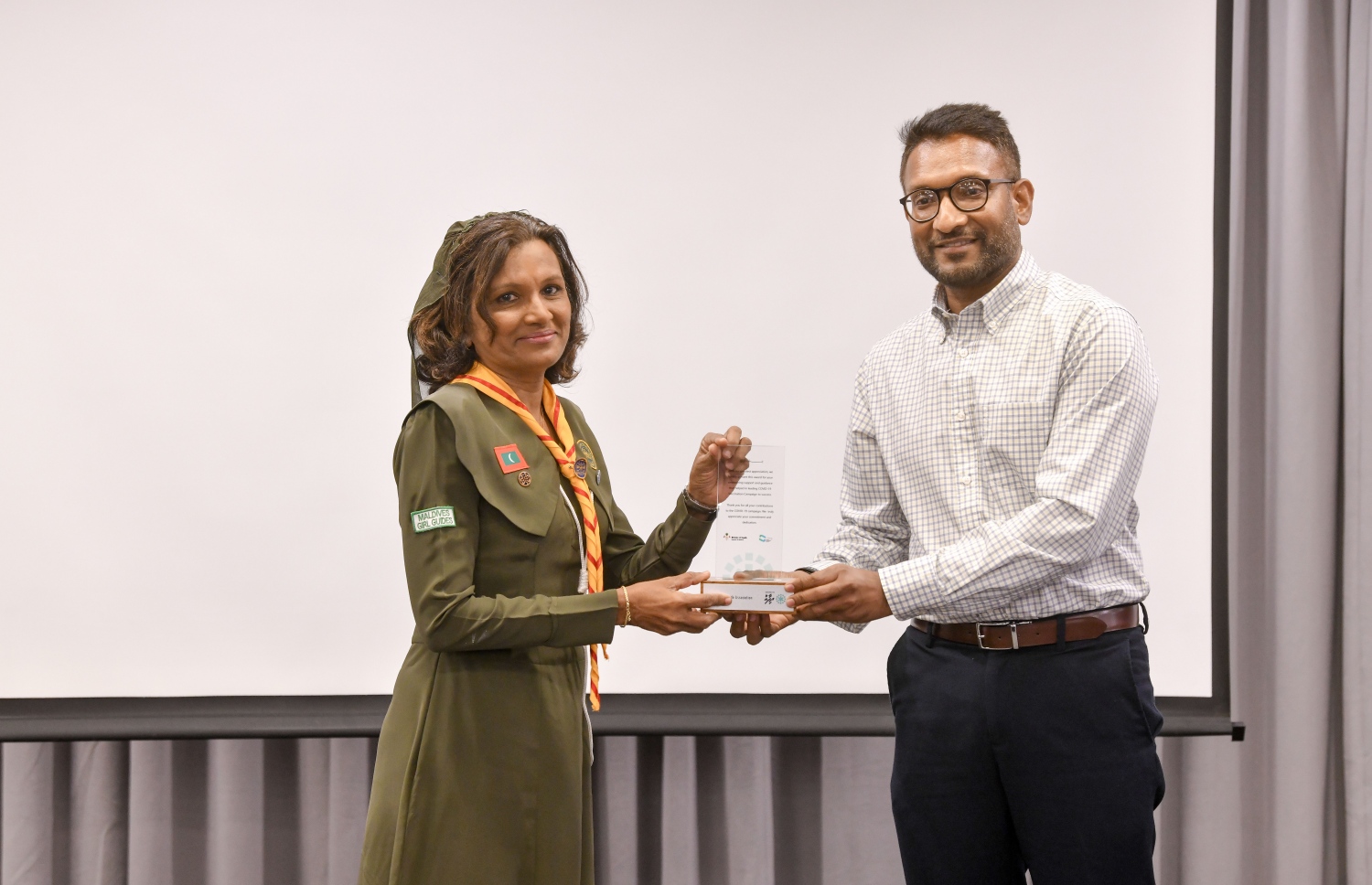 ކޮވިޑު ވެކްސިން ކެމްޕެއިންގެ ކާމިޔާބީ ފާހަގަކުރަން ރޭ ބޭއްވި ރަސްމިއްޔާތުގައި، އެ ކެމްޕެއިނަށް ގާލް ގައިޑް އެސޯސިއޭޝަނުން ދިން އެހީތެރިކަން ފާހަގަކޮށް، ސްޓޭޓް މިނިސްޓަރު ޑރ. ޝާހު މާހިރު، ގާލް ގައިޑް ކޮމިޝަނާ، ނަޝީދާއަށް ރޭ އެވޯޑު ހަވާލުކޮށްދެއްވަނީ-- ފޮޓޯ: ނިޝާން އަލީ/ މިހާރު