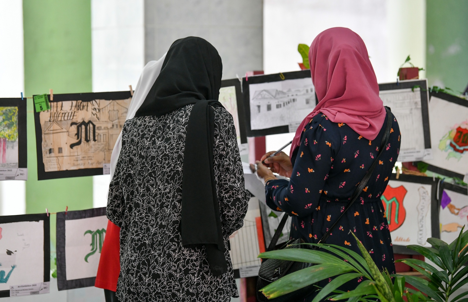 މަޖީދިއްޔާގެ ކުދިންގެ އަތްތެރި މަސައްކަތްތެރިންގެ މައުރަޒަށް އެ ސްކޫލުގެ ކުދިންނާއި މުވައްޒަފުން ހުށަހެޅި އައިޓަމްތައް ދެ ޓީޗަރަކު ބަލަނީ.---ފޮޓޯ: ފަޔާޒު މޫސާ| މިހާރު