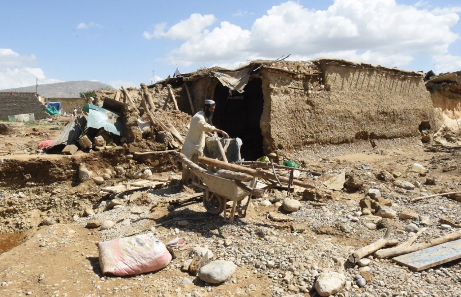 ޕާކިސްތާން: އޮގަސްޓް 27، 2022: މޫސުން ގޯސްވެ ޕާކިސްތާންގައި އާދަޔާ ހިލާފަށް ފެންބޮޑުވެފައި: މި ހާދިސާގައި ގެއްލުން ލިބުނު ގެއެއްގައި މީހަކު ގޭތެރޭގައި ހުރި ކުނިބުނިތައް ސ،ާފުކުރަނީ، މިހާތަނަށް 1000 އަށް ވުރެ ގިނަ މީހުން ވަނީ މަރުވެފައި.-- ފޮޓޯ: އޭއެފްޕީ