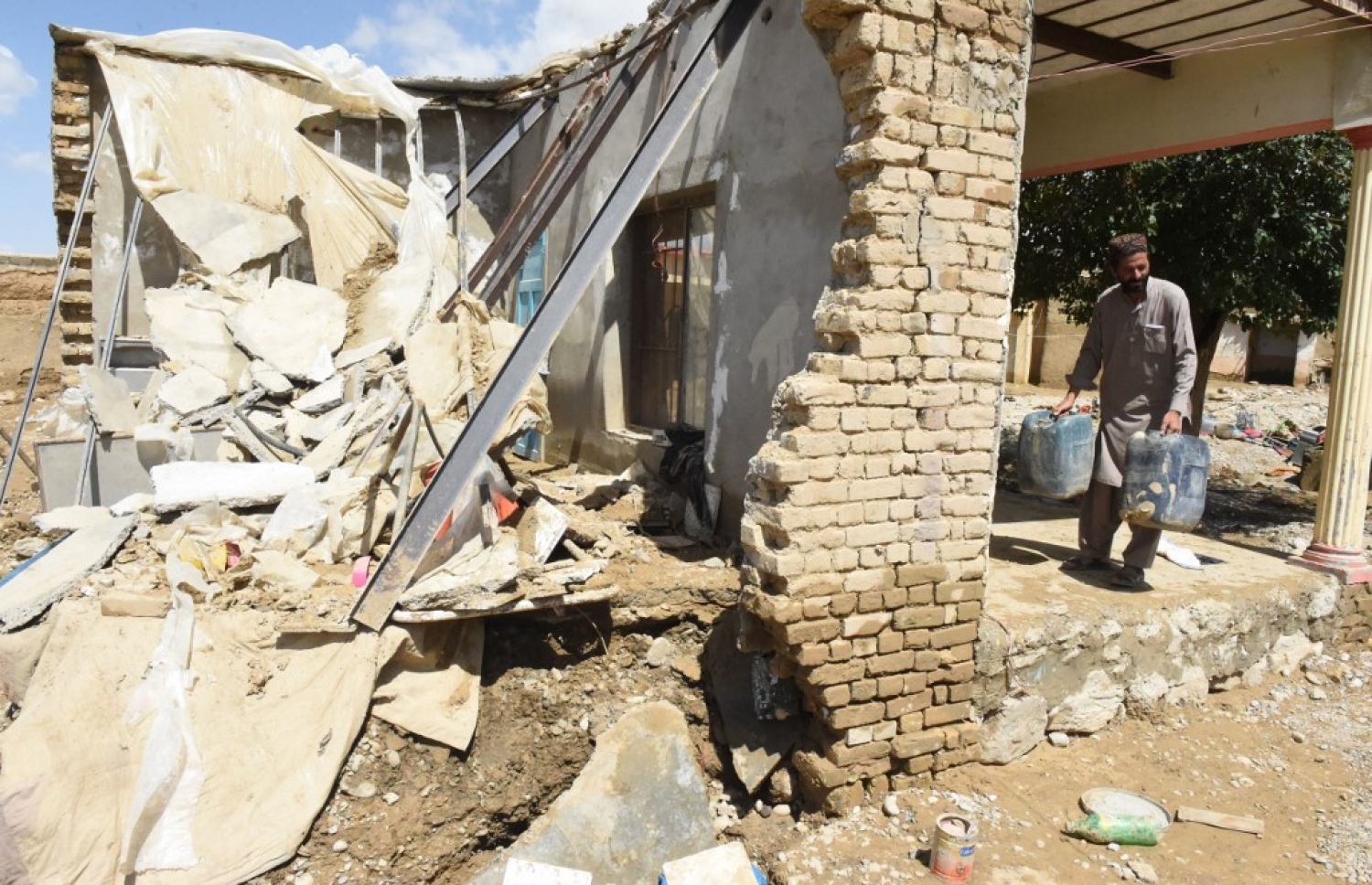 ޕާކިސްތާން: އޮގަސްޓް 27، 2022: މޫސުން ގޯސްވެ ޕާކިސްތާންގައި އާދަޔާ ހިލާފަށް ފެންބޮޑުވެފައި: މި ހާދިސާގައި ގެއްލުން ލިބުނު ގެ އެއްގައި މީހަކު ގޭތެރޭގައި ހުރި ކުނިބުނި ސާފުކުރަނީ،، މިހާތަނަށް 1000 އަށް ވުރެ ގިނަ މީހުން ވަނީ މަރުވެފައި.-- ފޮޓޯ: އޭއެފްޕީ