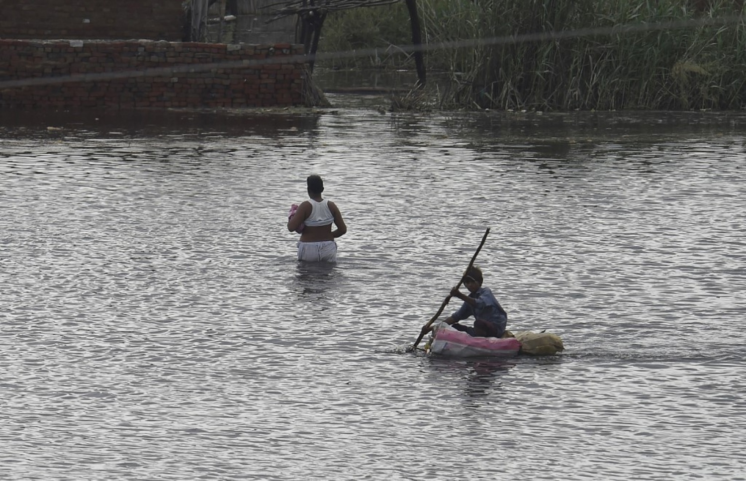 ޕާކިސްތާން: އޮގަސްޓް 27، 2022: ޕާކިސްތާންގެ އަވަށެއްގައި މޫސުން ގޯސްވެ، މަގުތަކުގައި އާދަޔާ ހިލާފަށް ފެންބޮޑުވުމުން ބަޔަކު ކަނދުފޮއްޗެއްގައި ކަނބާފައި ދަނީ: މިހާތަނަށް 1000 އަށް ވުރެ ގިނަ މީހުން ވަނީ މަރުވެފައި.-- ފޮޓޯ: އޭއެފްޕީ