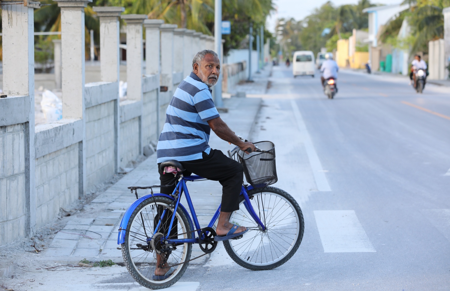 ގަމުގެ މަގެއް މަތީގައި މީހަކު ބައިސްކަލެއްގައި އިށީނދެލައިގެން.