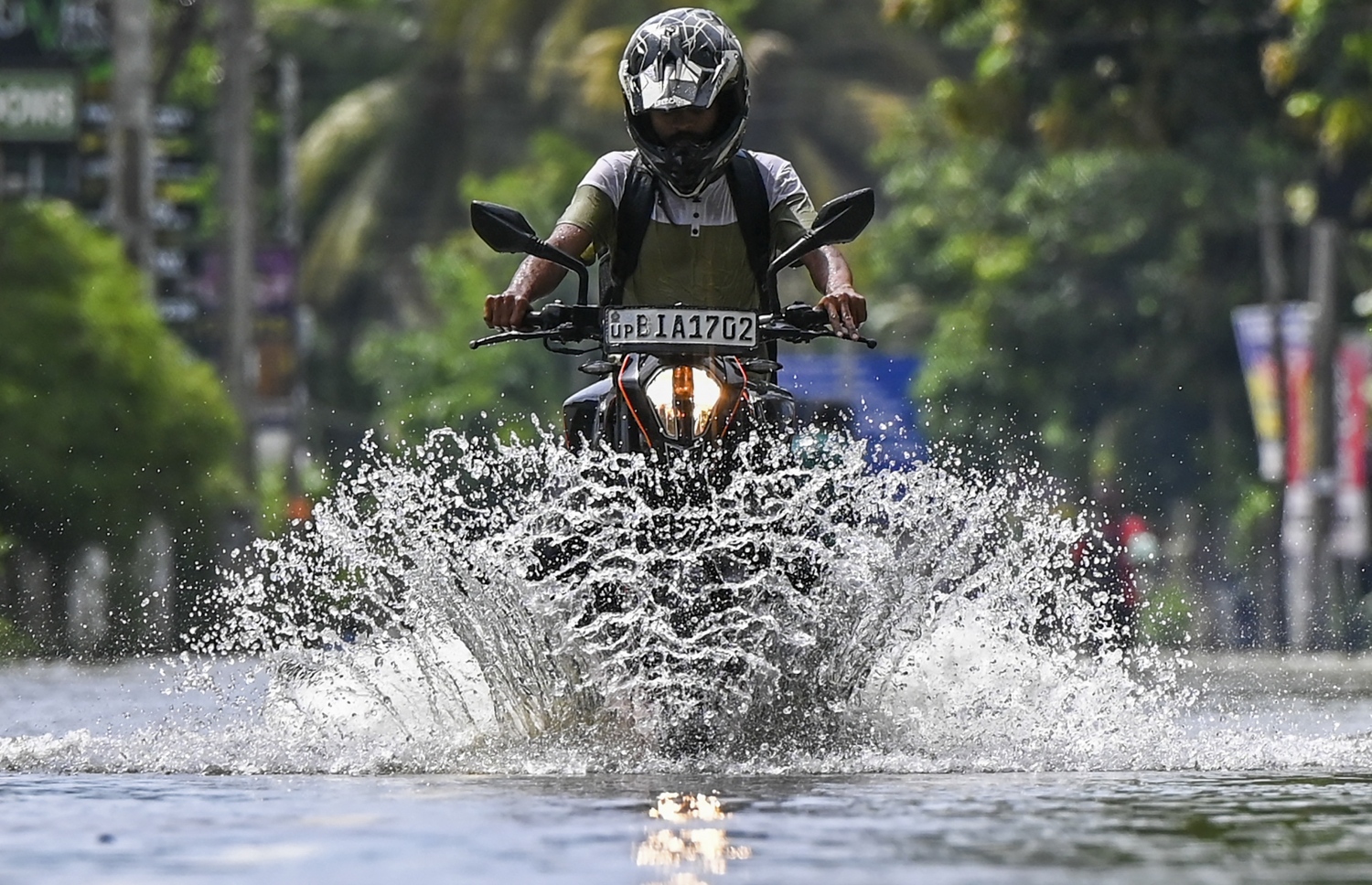 އޮކްޓޫބަރ 16، 2022؛ ބޯކޮށް ވާރޭ ވެހުމުގެ ސަބަބުން ވެރިރަށް ކޮލޮމްބޯގެ މަގެއްގައި ބޮޑުވެފައިވާ ފެންގަނޑުގެ ތެރޭގައި މީހަކު ސައިކަލްގައި ދަނީ. --އޭއެފްޕީ