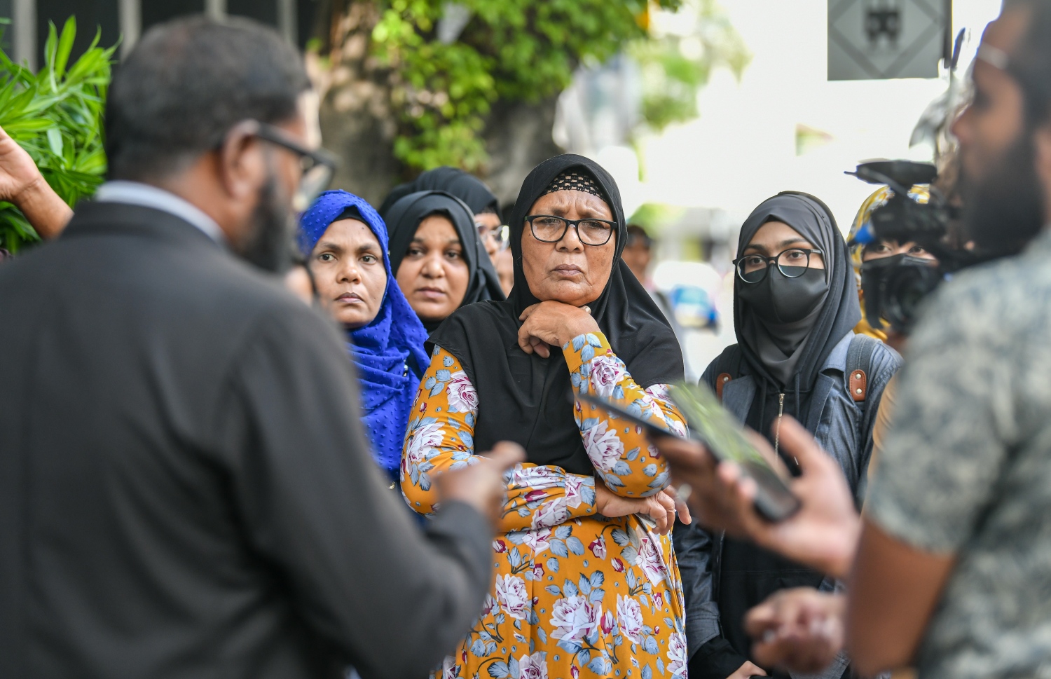 ރަޝީދުގެ މަންމަ އާއި އާއިލާގެ ބައެއް މެމްބަރުން ވަކީލުންނާ އެކު ކޯޓު ބޭރުގައި: އޭނާގެ ހަށިގަނޑު ހޯމަދުވަހު ބޭރަށް ގެންދާކަން އެނގުނީ ދައުލަތުން ކޯޓުގައި ހާމަކުރުމުން ކަމަށް ވަކީލުން ބުނޭ. -- ފޮޓޯ: ފަޔާޒް މޫސާ | މިހާރު