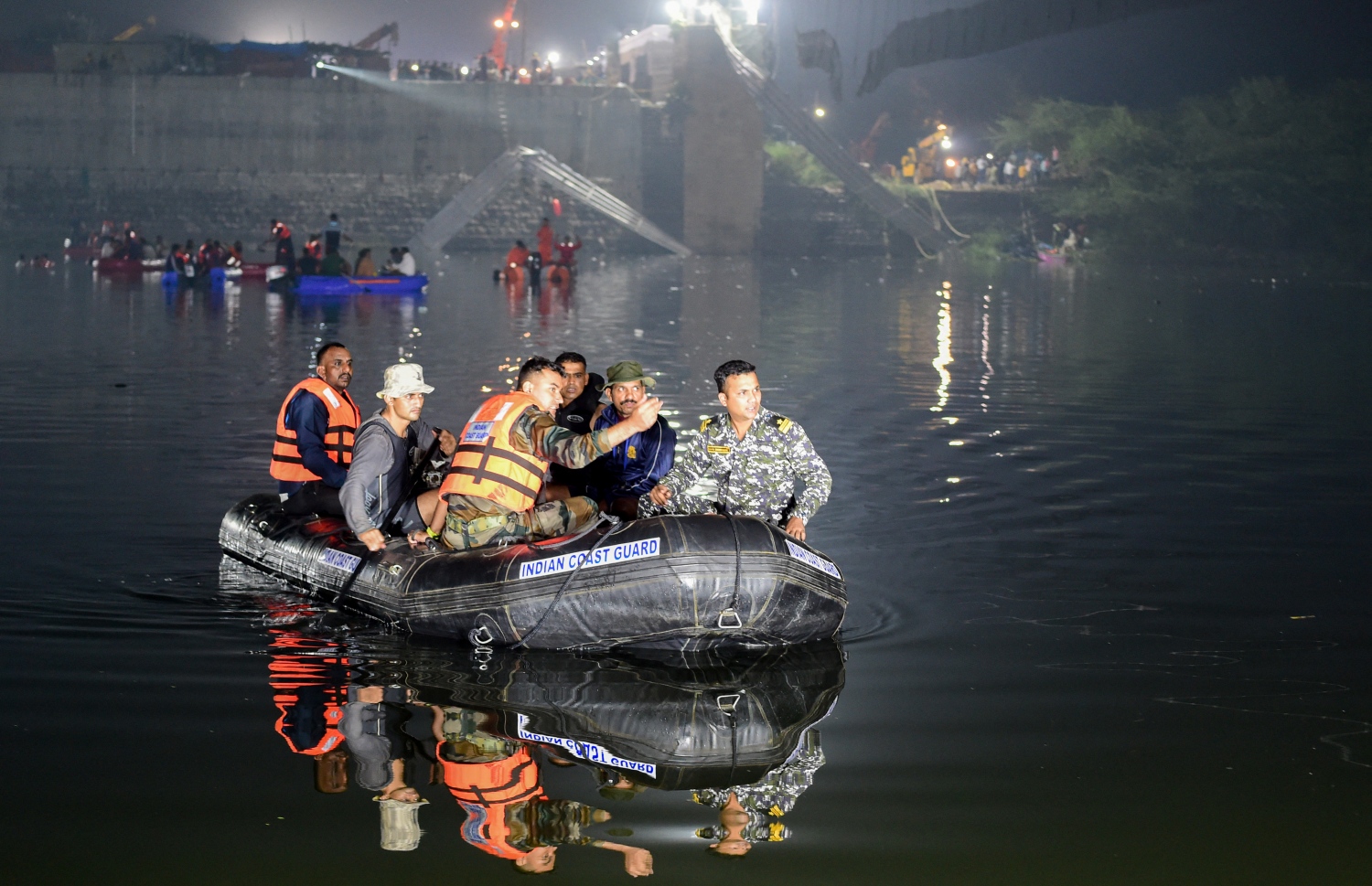 އޮކްޓޫބަރ 30، 2022؛ އިންޑިއާގެ ގުޖުރާތުގައި ކޯރެއްގެ މަތިން އަޅާފައި އޮތް އެލުވާ ބްރިޖެއް ކަނޑައިގެން ގޮސް ވެއްޓުމުގެ ހާދިސާގައި މަރުވި މީހުންނާއި ކޯރުގެ ތެރެއަށް ގެއްލިފައިވާ ހޯދުމުގެ މަސައްކަތުގައި އިންޑިއާގެ ސަލާމަތީ ބާރުތަކުގެ ޓީމުތައް މަސައްކަތް ކުރަނީ. --އޭއެފްޕީ