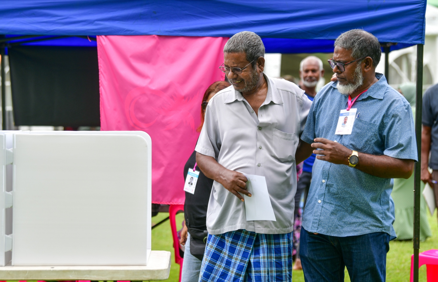 ޕީޕީއެމް/ޕީއެންސީގެ ދާއިރާތަކުގެ އިންތިހާބުގައި މާލޭގެ ވޯޓުލުން ހެންވޭރު ދަނޑުގައި ބާއްވާއިރު، ވޯޓުލާ މީހަކު، އިންތިހާބީ އޮފިޝަލުންތަކަކާއެކު ވޯޓުލާ މަރުކަޒު ކައިރީގައި މަޑުކޮށްލައިގެން.--- ފޮޓޯ: ނިޝާން އަލީ | މިހާރު