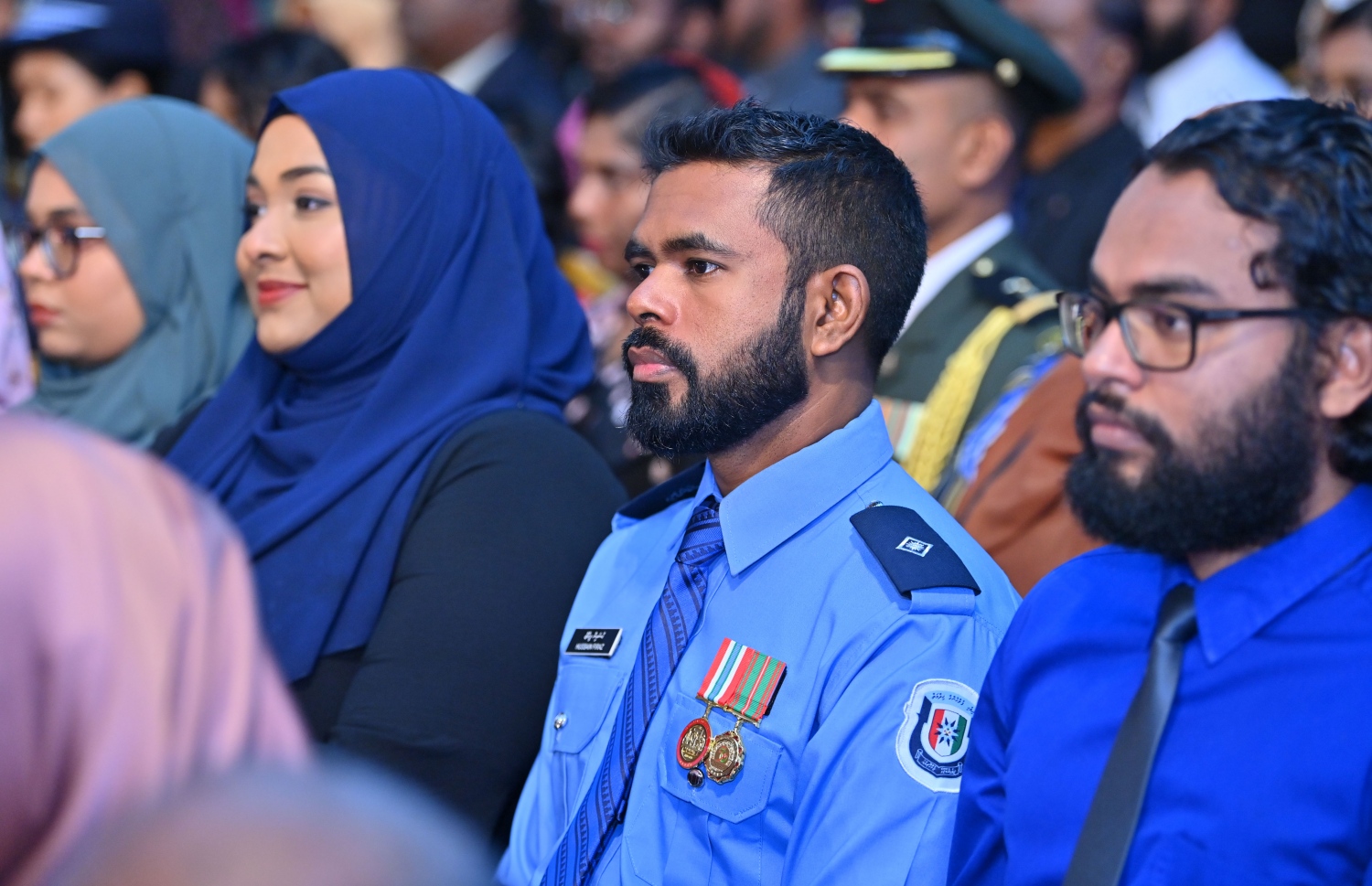 މި އަހަރުގެ ޖުމްހޫރީ ދުވަހުގެ ރަސްމީ ޖަލްސާގައި ފުލުހުންގެ މީޑިއާގެ އިސް އޮފިސަރެއް ކަމަށްވާ ސަބް އިންސްޕެކްޓަ އޮފް ޕޮލިސް ހުސައިން ފިރާޝް ބައިވެރިވެވަޑައިގަނަންވަނީ.--- ފޮޓޯ: ރައީސް އޮފީސް