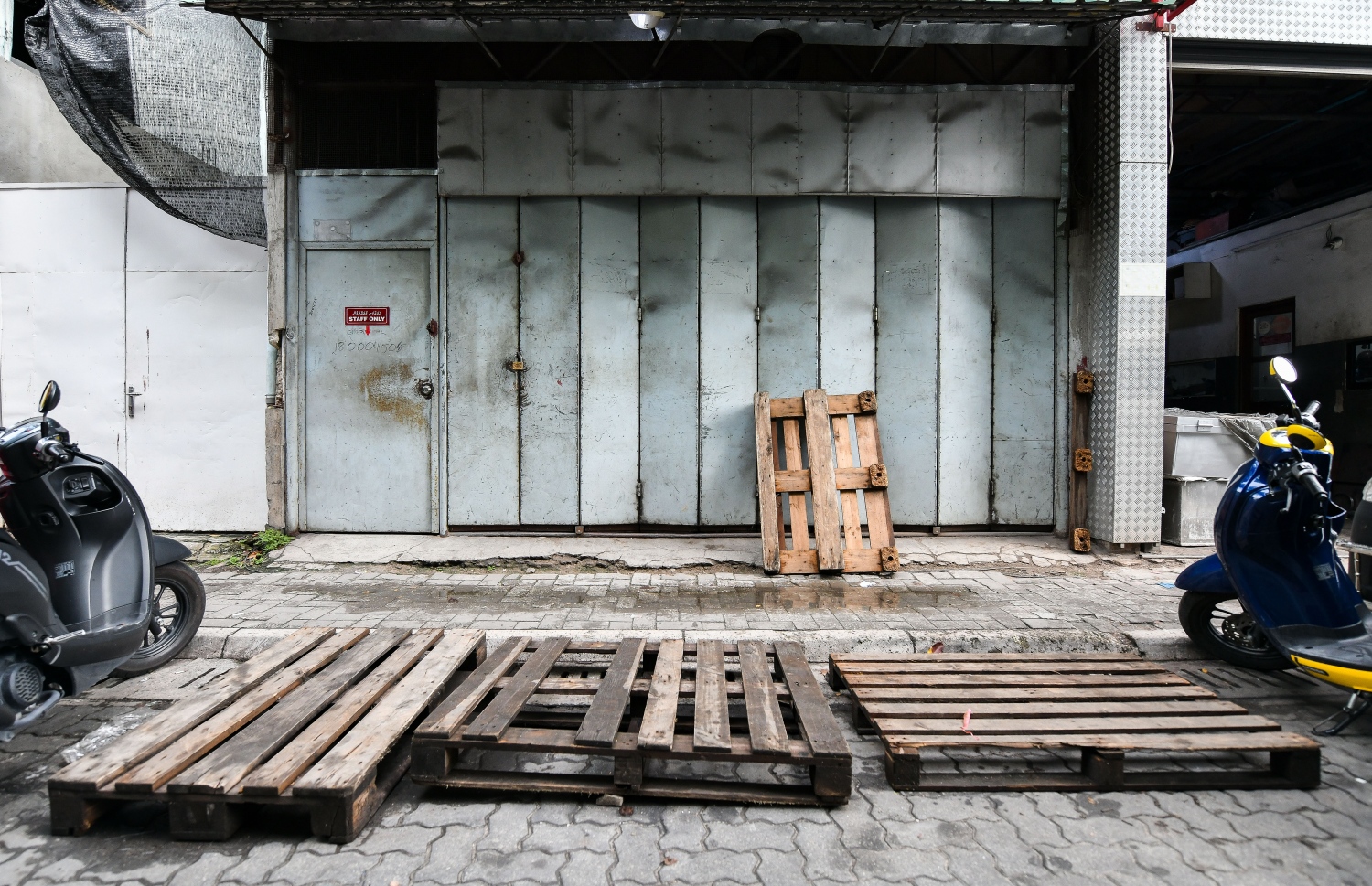 މާލޭގެ ގަރާޖެއްގެ ކުރިމަތީގައި ޕެލެޓުތައް ބަހައްޓާފައި -- ފޮޓޯ: ފަޔާޒް މޫސާ | މިހާރު