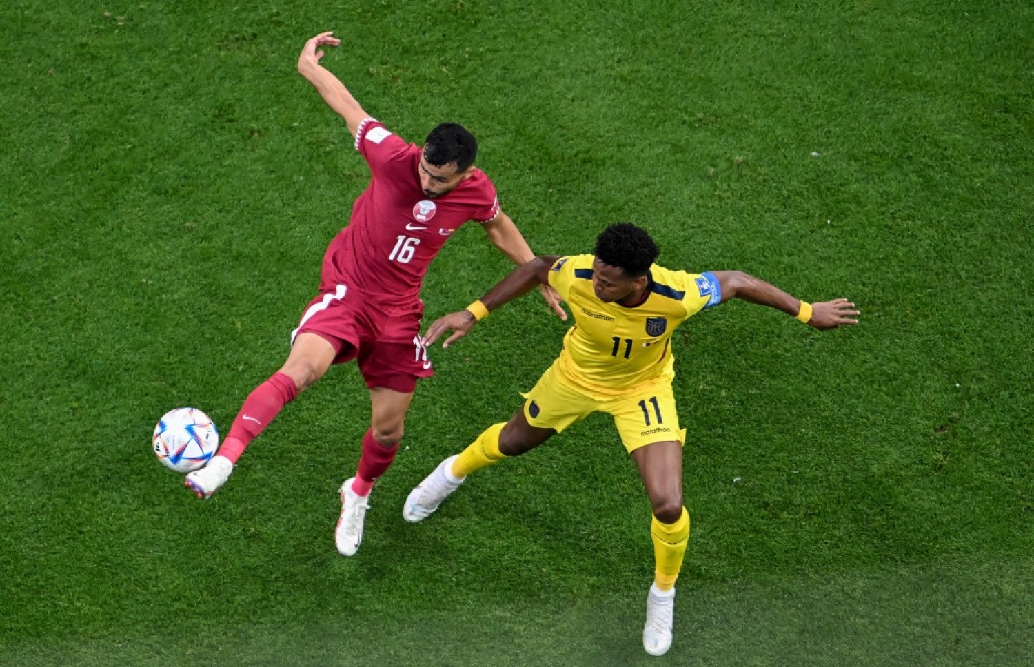 ވޯލްޑް ކަޕުގެ ފުރަތަމަ މެޗުގައި ގަތަރުގެ ޑިފެންޑަރު ބުއަލިމް ކޫކީ (ވ) އިކުއެޑޯގެ ފޯވާޑް މައިކަލް އެސްޓްރާޑާގެ އަތުން ބޯޅަ ހޯދުމަށް މަސައްކަތް ކުރަނީ. -- ފޮޓޯ: އޭއެފްޕީ