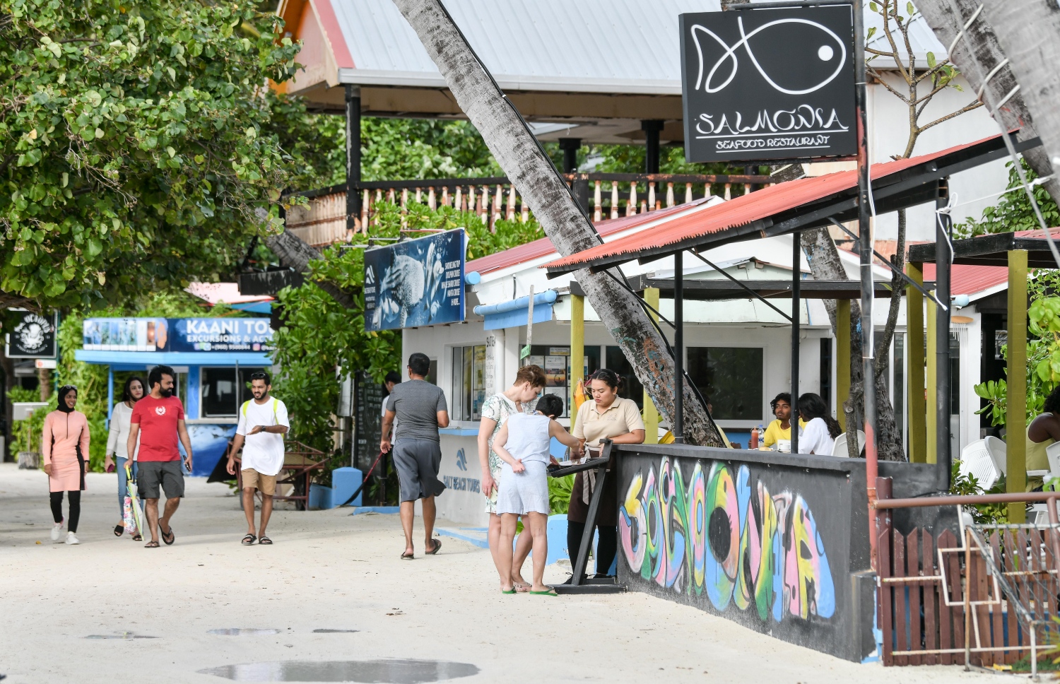 މާފުށީގެ ރެސްޓޯރެންޓެއް ކައިރީގައި ޓޫރިސްޓުންތަކެއް މަޑުކޮށްލައިގެން: އެ ރަށުގައި ގިނަ އަދަދެއްގެ ރެސްޓޯރެންޓް ހުރޭ-- ފޮޓޯ: ނިޝާން އަލީ/ މިހާރު