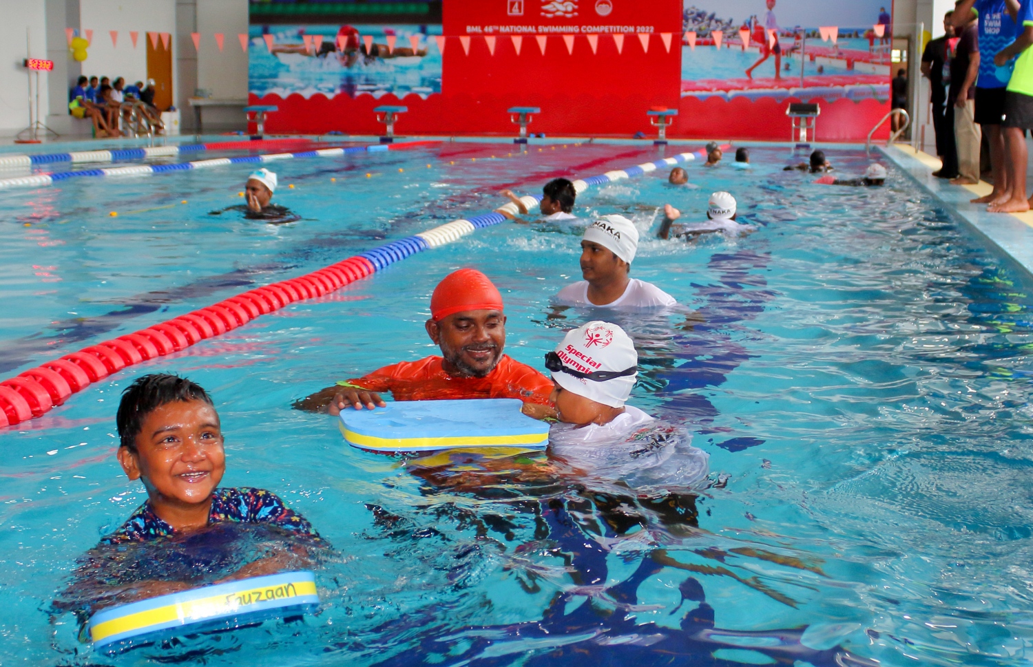 ނުކުޅެދުންތެރިކަން ހުންނަ ކުދިންނަށް ހާއްސަ ކޮށްގެން ނިއު ލެގޫން ސްވިމިން ކްލަބުން ބޭއްވި ސްޕެޝަލް އޮލިމްޕިކް ފެތުމުގެ ހަރަކާތުގައި ބައެއް ކުދިންނަށް އެ ކްލަބްގެ އޮފިޝަލަކު އެހީތެރިވަނީ.--- ފޮޓޯ: ނިއު ލެގޫން ސްވިމިން ކްލަބް