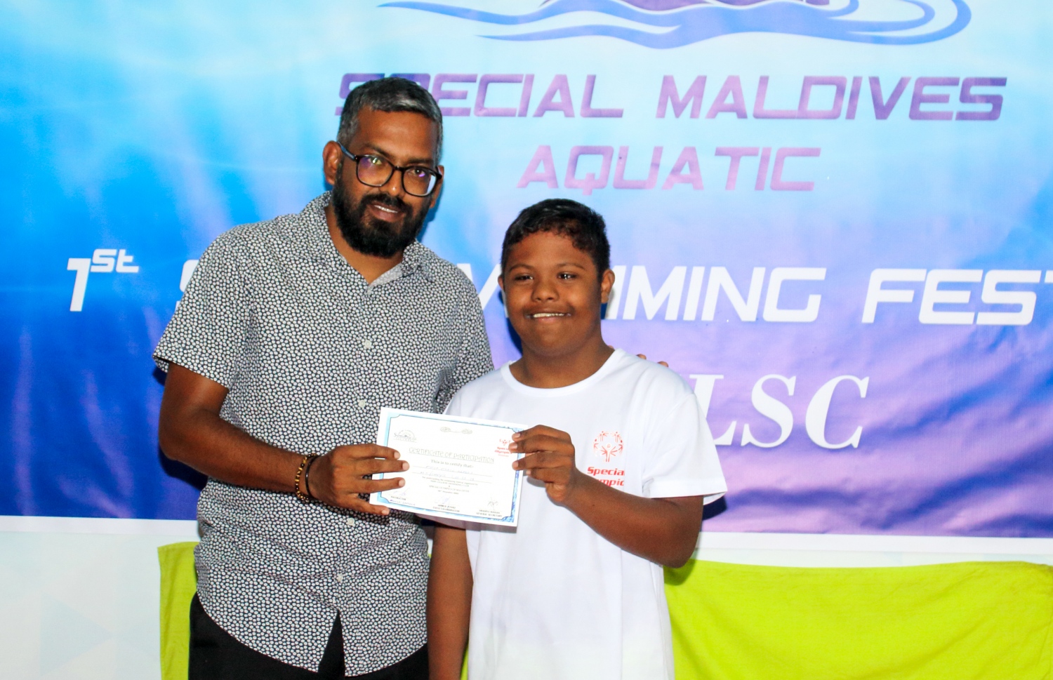 ނިއު ލެގޫން ސްވިމިން ކްލަބުން އިސްނަގައިގެން ބޭއްވި ސްޕެޝަލް އޮލިމްޕިކްގައި ބައިވެރިވި ކުއްޖަކަށް ސެޓްފިކެޓް ހަވާލު ކުރަނީ: އެ ހަރަކާތުގައި 60 ކުއްޖަކު ބައިވެރިވި.--- ފޮޓޯ: ނިއު ލެގޫން ސްވިމިން ކްލަބް