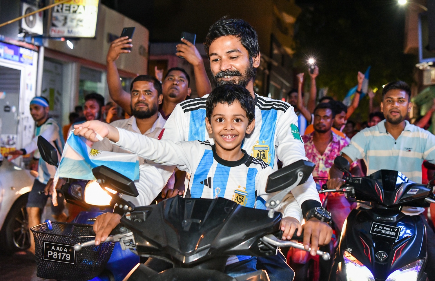 ގަތަރުގައި ބޭއްވި ވޯލްޑް ކަޕް އާޖެންޓީނާ އިން ކާމިޔާބު ކުރުމާ ގުޅިގެން މާލޭގެ މަޖީދީމަގުގައި ކުރިއަށް ގެންދިޔަ އުފާފާޅުކުރުމުގެ ހަރަކާތުގައި ކުޑަކުއްޖަކު ބައިވެރިވަނީ: މިރޭގެ ސެލެބްރޭޝަންގައި ވަރަށް ކުޑަކުދިން ވެސް މާލޭގެ މަގުތަކުން ފެނުނު.--- ފޮޓޯ: ފަޔާޒު މޫސާ | މިހާރު