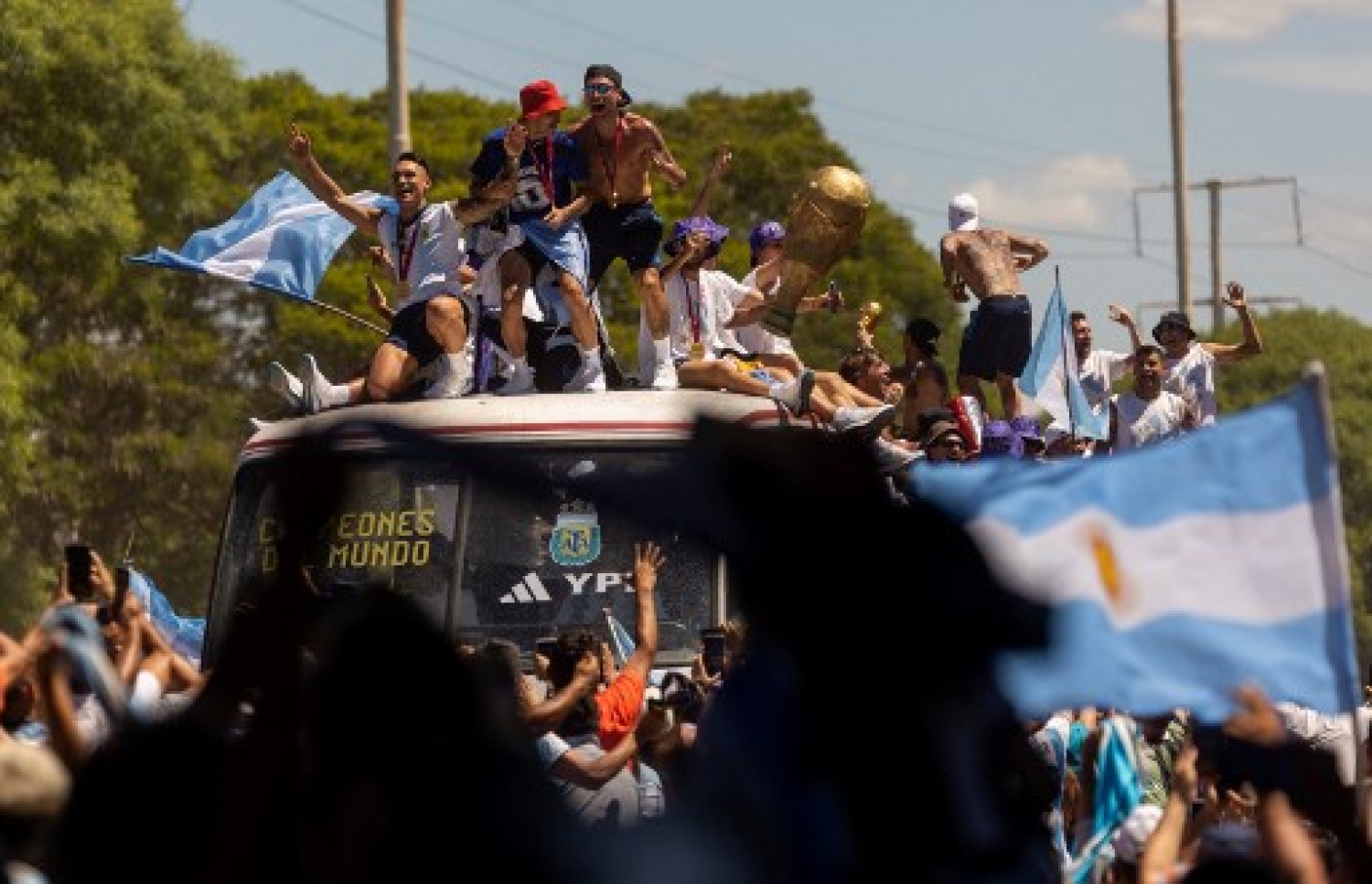 ވޯލްޑް ކަޕުގެ ތަށި ހިފައިގެން އާޖެންޓީނާ ކުޅުންތެރިން އެ ގައުމުގެ ވެރިރަށް ބީނޯސް އޭރީޒްގައި ބޭއްވި ބަސް ޕެރޭޑުގައި އާންމުން ބައިވެރިވެ އުފާފާޅުކުރަނީ: މިއީ އާޖެންޓީނާ ވޯލްޑް ކަޕް ތަށި އުފުލާލި ތިންވަނަ ފަހަރު.-- ފޮޓޯ: އޭއެފްޕީ