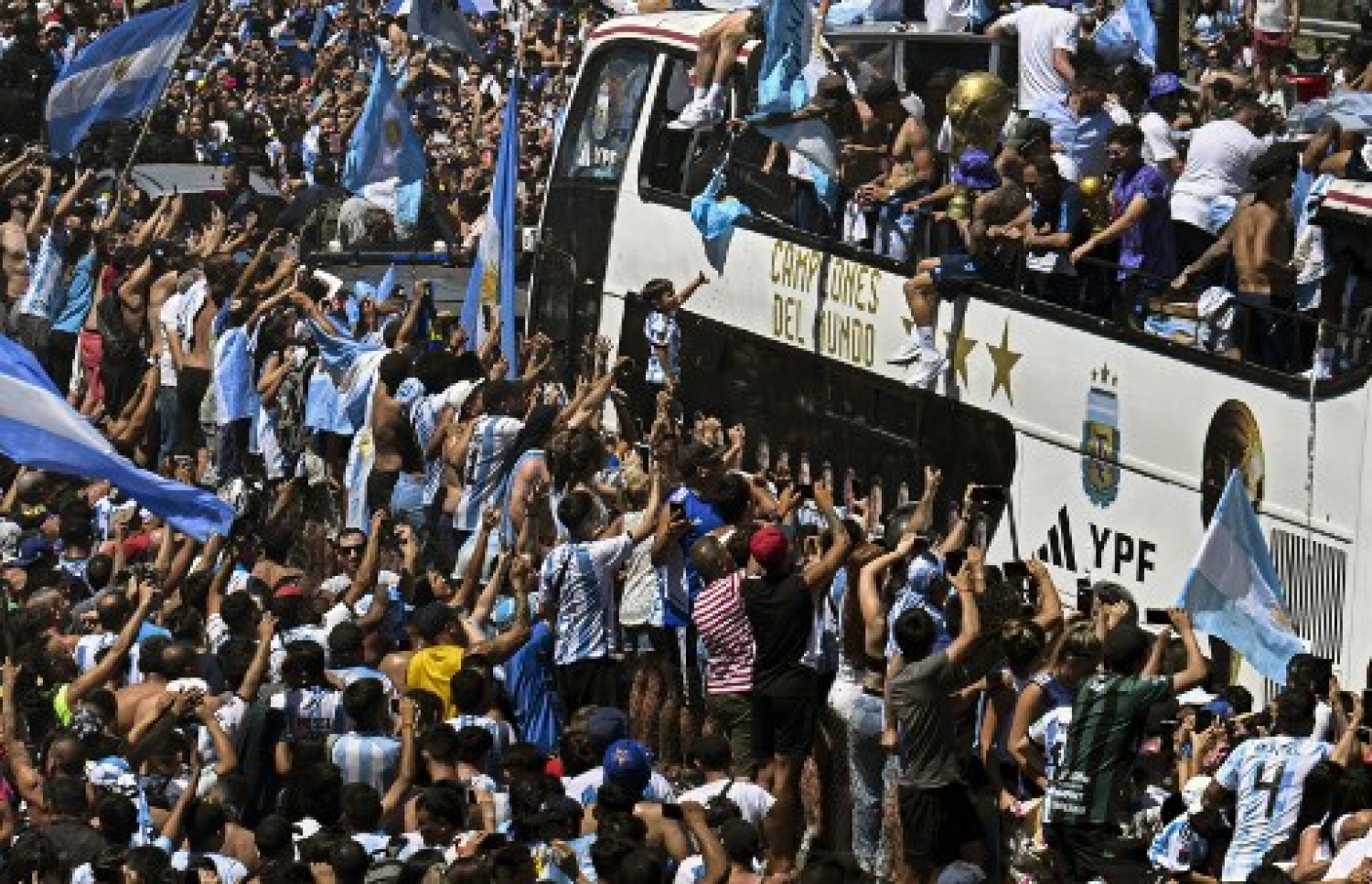 ވޯލްޑް ކަޕުގެ ތަށި ހިފައިގެން އާޖެންޓީނާ ކުޅުންތެރިން އެ ގައުމުގެ ވެރިރަށް ބީނޯސް އޭރީޒްގައި ބޭއްވި ބަސް ޕެރޭޑުގައި އާންމުން ބައިވެރިވެ އުފާފާޅުކުރަނީ: މިއީ އާޖެންޓީނާ ވޯލްޑް ކަޕް ތަށި އުފުލާލި ތިންވަނަ ފަހަރު.-- ފޮޓޯ: އޭއެފްޕީ