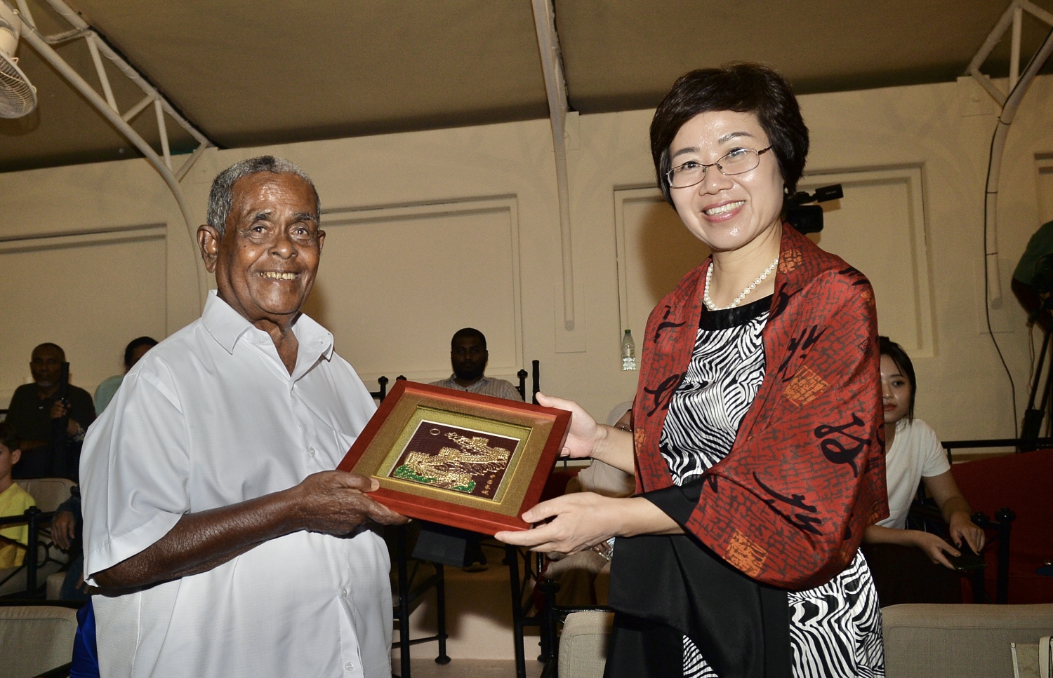 ޓޫރިޒަމްގައި އެންމެ ބޮޑު ކާމިޔާބީއެއް ހޯއްދެވި އެއް ވިޔަފާރިވެރިޔާ މުހައްމަދު މޫސާ (އުއްޗު) ގެ މި އަހަރުގެ އުފަން ދުވަހުގެ ހަފުލާ އަށް ކުރެއްދޫ ރިސޯޓަށް ވަޑައިގެންނެވި، ރާއްޖޭގައި ހުންނަވާ ޗައިނާގެ ސަފީރު، އުއްޗު އަށް އުފަން ދުވަހުގެ ހަދިޔާއެއް އަރުވަނީ.---ފޮޓޯ: އެލީޒް