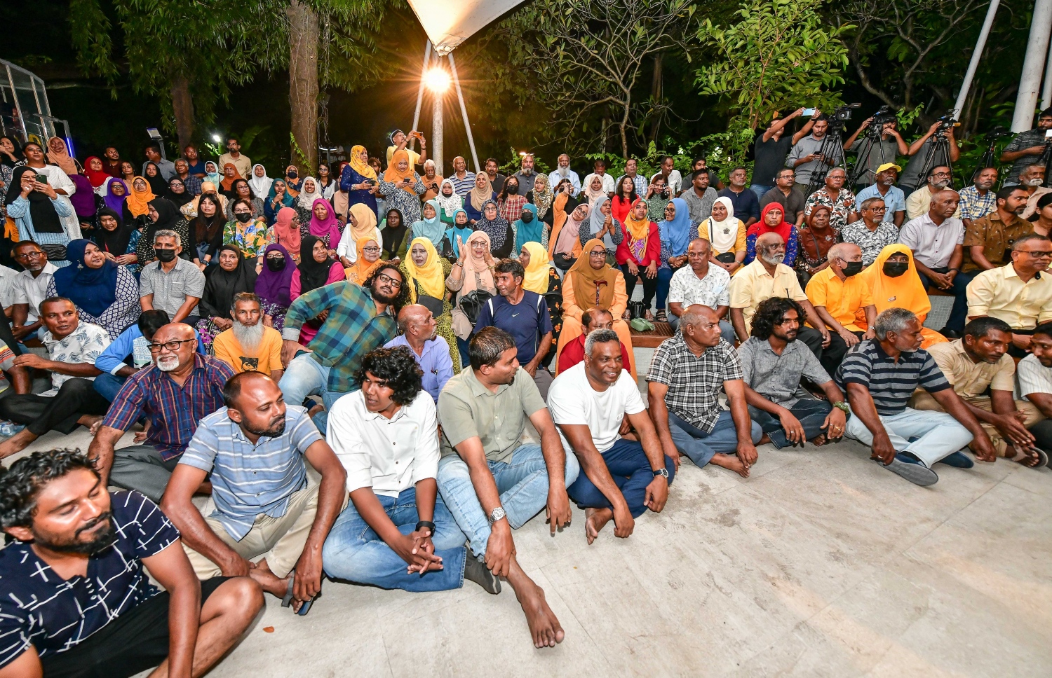 އަންނަ މަހުގެ 28 ގައި ބާއްވާ އެމްޑީޕީގެ ރިޔާސީ ޕްރައިމަރީގައި ވާދަކުރައްވާ، އެ ޕާޓީގެ ރައީސް މުހައްމަދު ނަޝީދުގެ ކެމްޕެއިން ފެށުމަށް ސަލްޓަން ޕާކުގައި ބޭއްވި ޖަލްސާގައި ބައިވެރިވި ބައެއް މީހުން ބިންމަތީގައި އިށީނދެގެން.---ފޮޓޯ: ނިޝާން އަލީ| މިހާރު