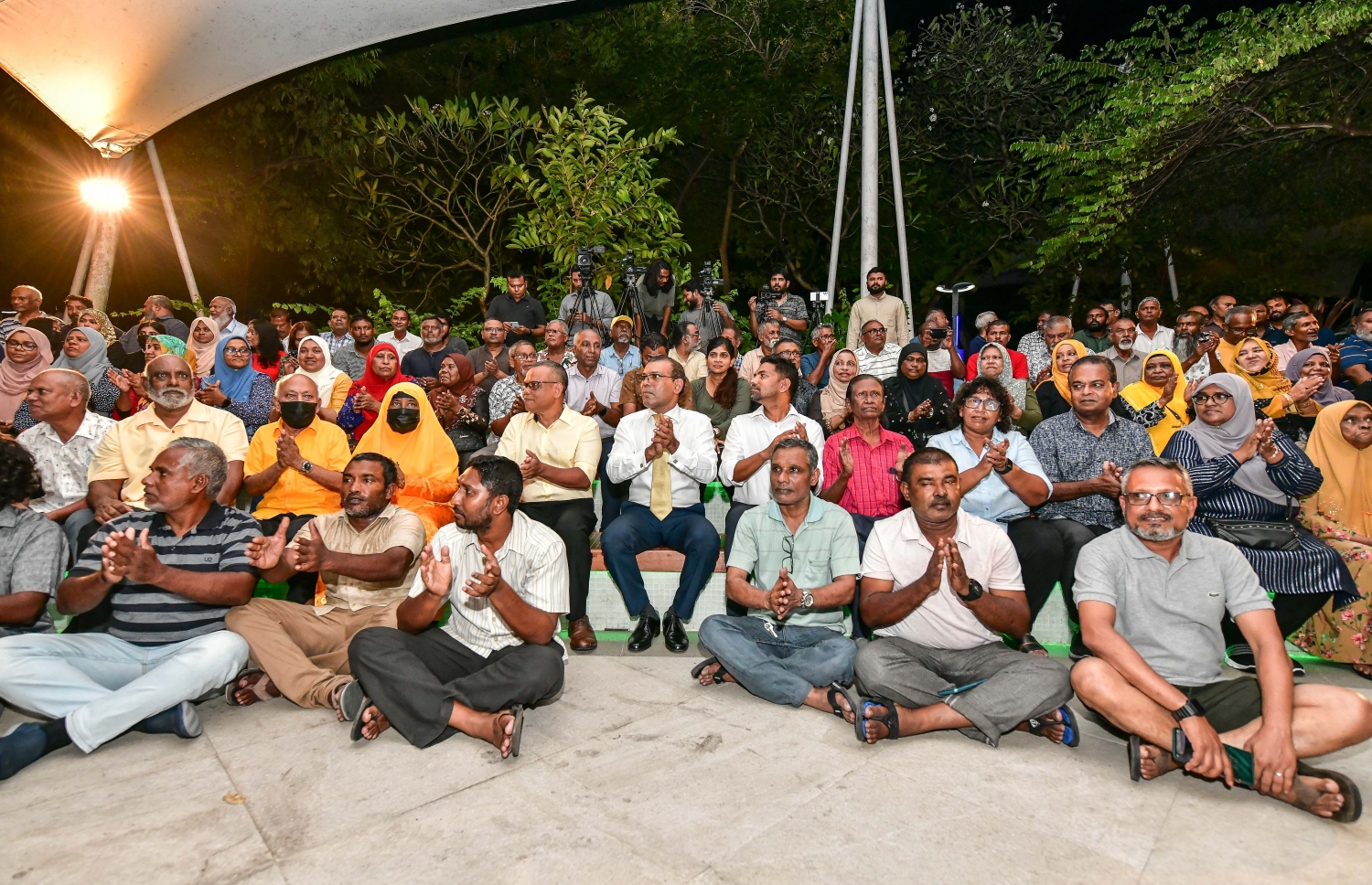 އަންނަ މަހުގެ 28 ގައި ބާއްވާ އެމްޑީޕީގެ ރިޔާސީ ޕްރައިމަރީގައި ވާދަކުރައްވާ، އެ ޕާޓީގެ ރައީސް މުހައްމަދު ނަޝީދުގެ ކެމްޕެއިން ފެށުމަށް ސަލްޓަން ޕާކުގައި ބޭއްވި ޖަލްސާގައި ބައިވެރިވި ބައެއް މީހުން ބިންމަތީގައި އިށީނދެގެން.---ފޮޓޯ: ނިޝާން އަލީ| މިހާރު