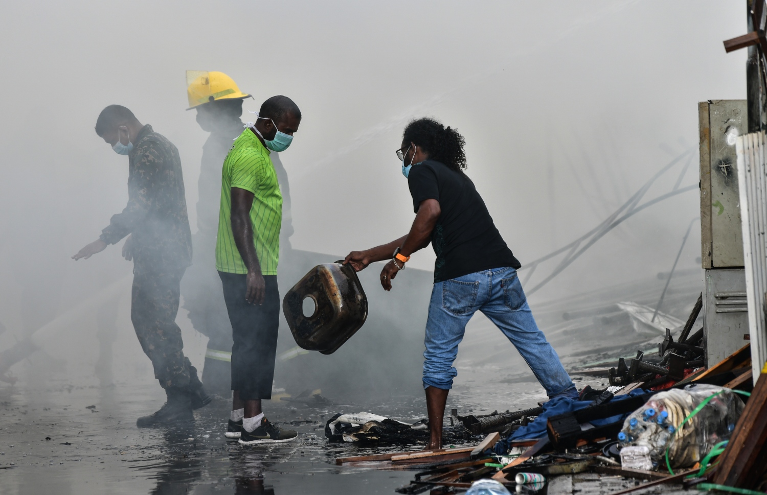 މާލޭގެ ދެކުނު ފަރާތު، ކުރީގެ އެއް ނަމްބަރު ކުނިކޮށި ހިމެނޭ "ނީލަން ފިހާރަ" އިގައި ހިނގާދިޔަ އަލިފާނުގެ ހާދިސާގައި އަލިފާންގަނޑު ނިއްވާލުމަށް އެމްއެންޑީއެފް އިން މަސައްކަތް ކުރަނީ.-- ފޮޓޯ: ނިޝާން އަލީ/ މިހާރު